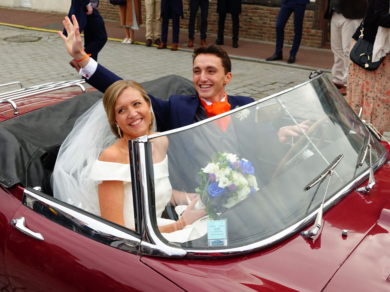 Classic red convertible car decorated for a wedding celebration.