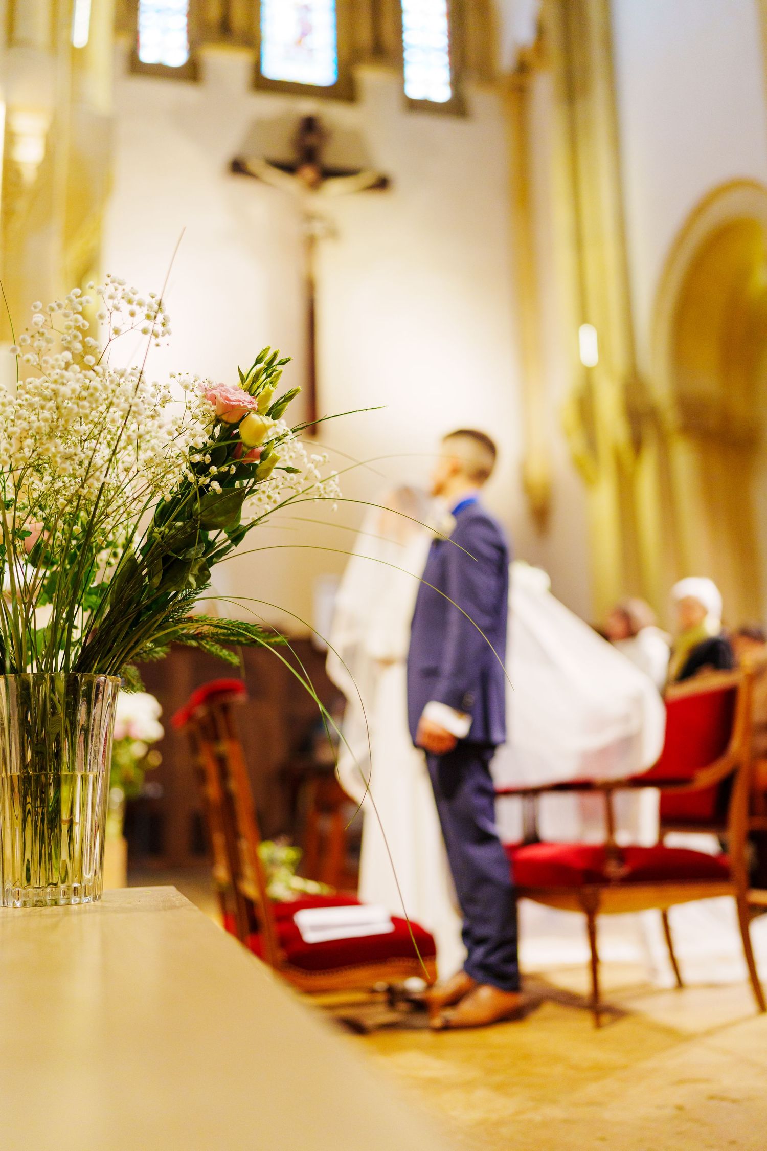 Elegant wedding venue interior with soft lighting and floral arrangements displayed in tall glass vases.