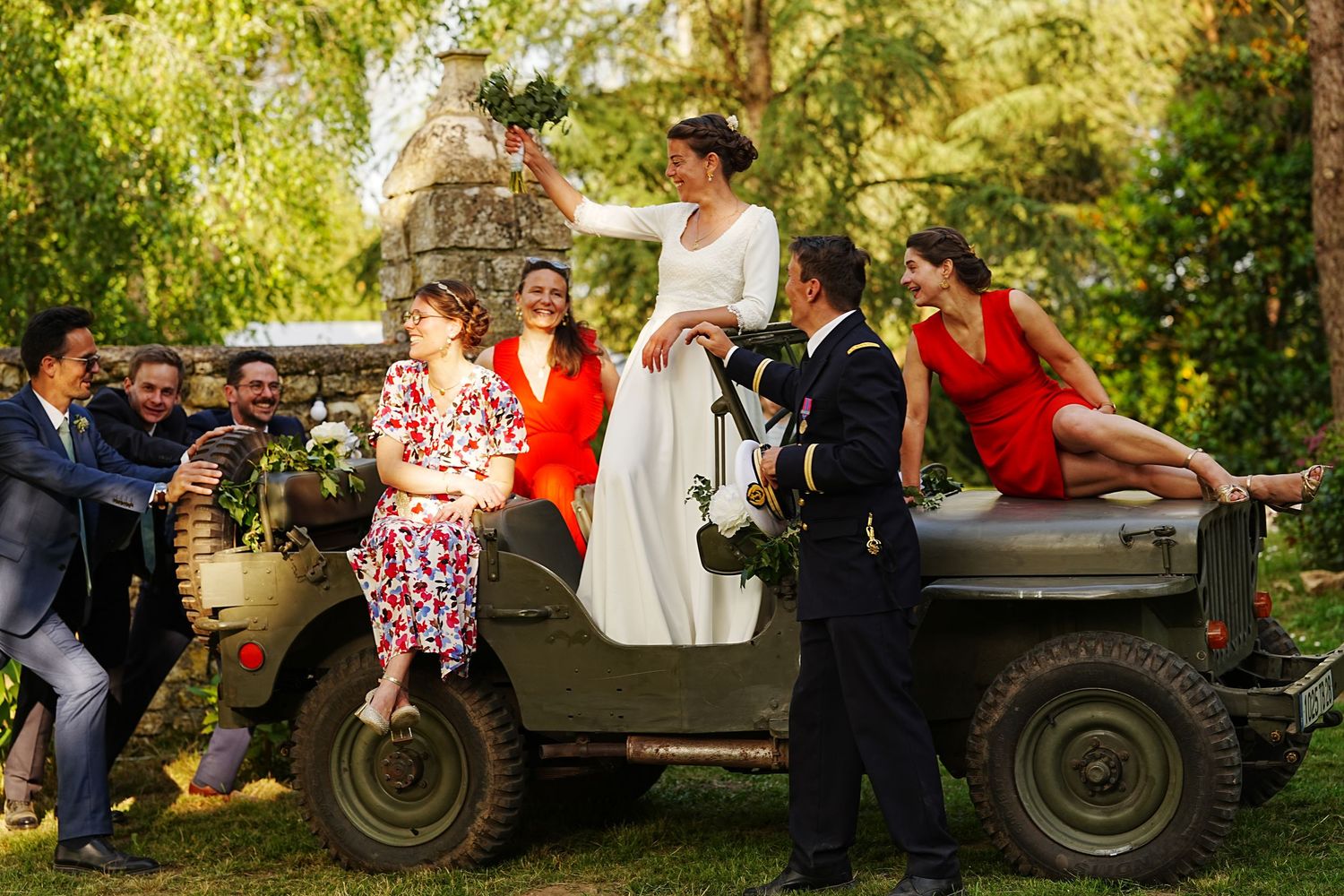 A couple dances outdoors near a vintage white military vehicle during a celebration.