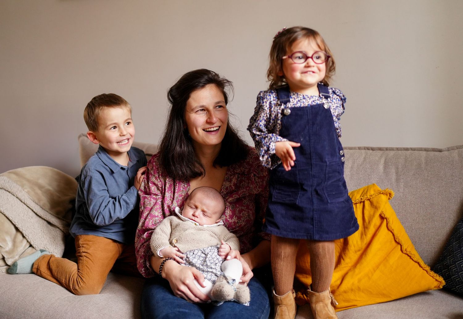 Family portrait on couch with children in casual setting.