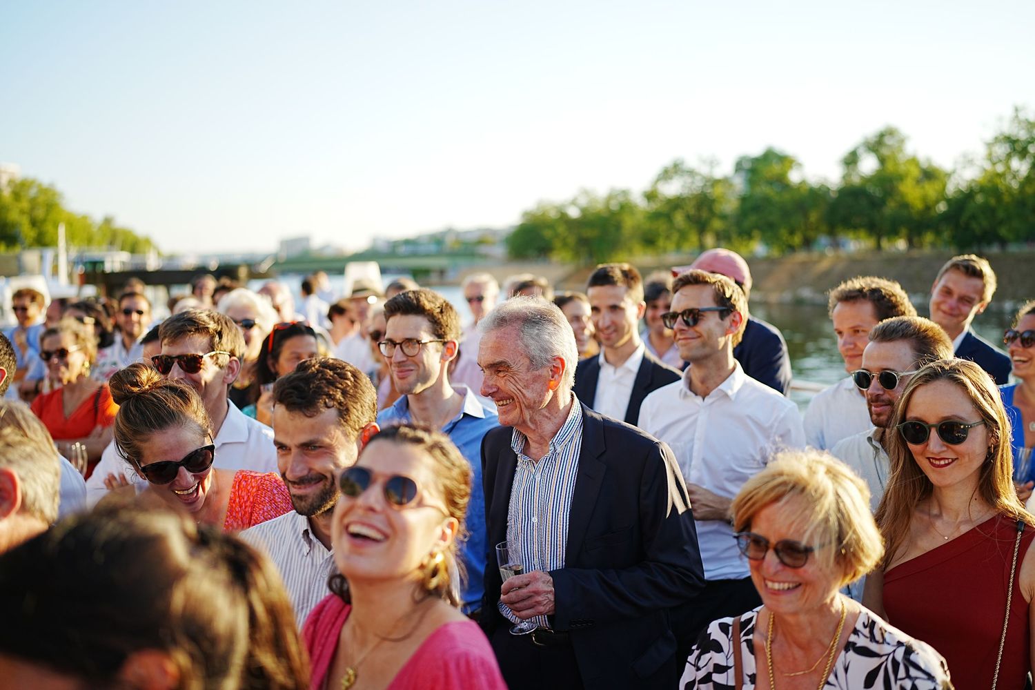 A large crowd of people gathered outdoors on a sunny summer day.