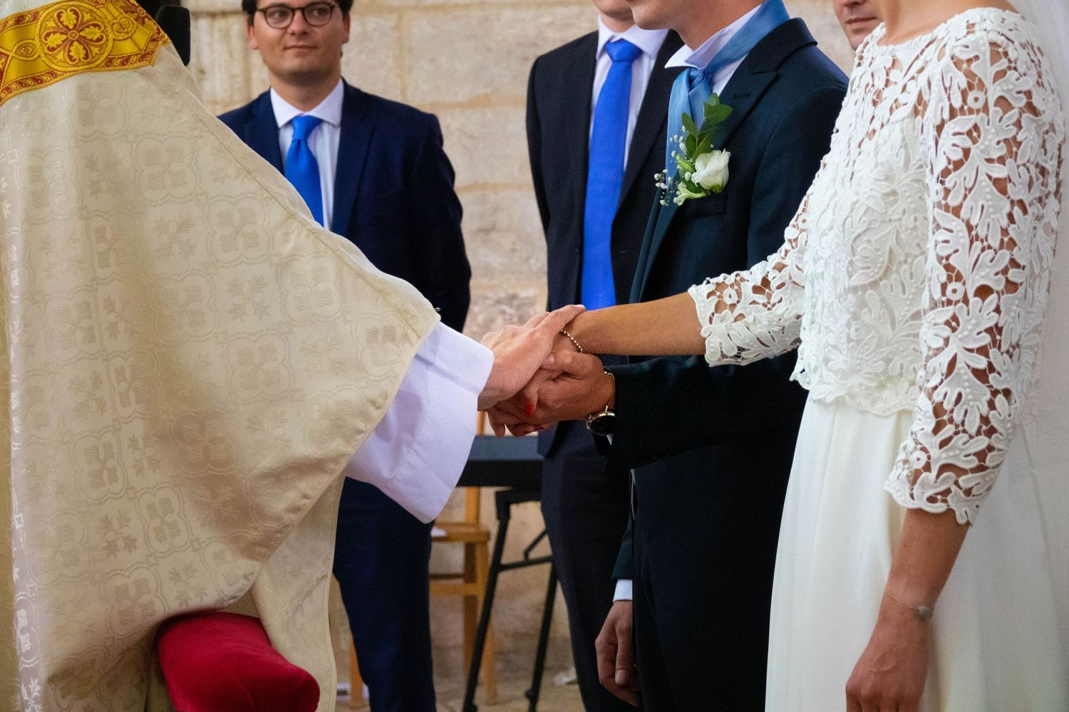 Wedding ceremony taking place in an ornate church with guests watching.