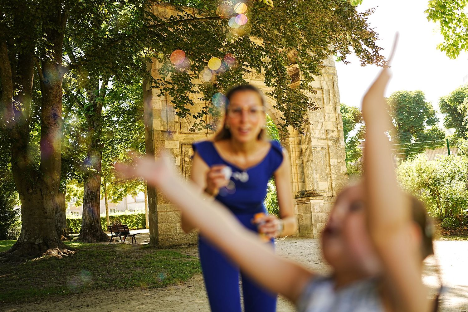 Playful outdoor scene with blurred motion and sunlight filtering through trees.