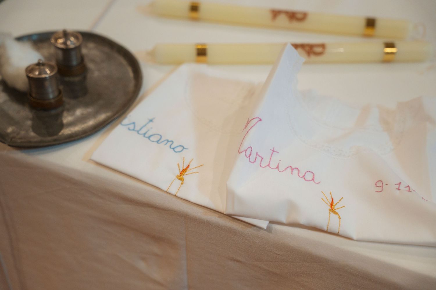 Elegant wedding napkins with handwritten names Tatiana and Martina on a white table with candles.