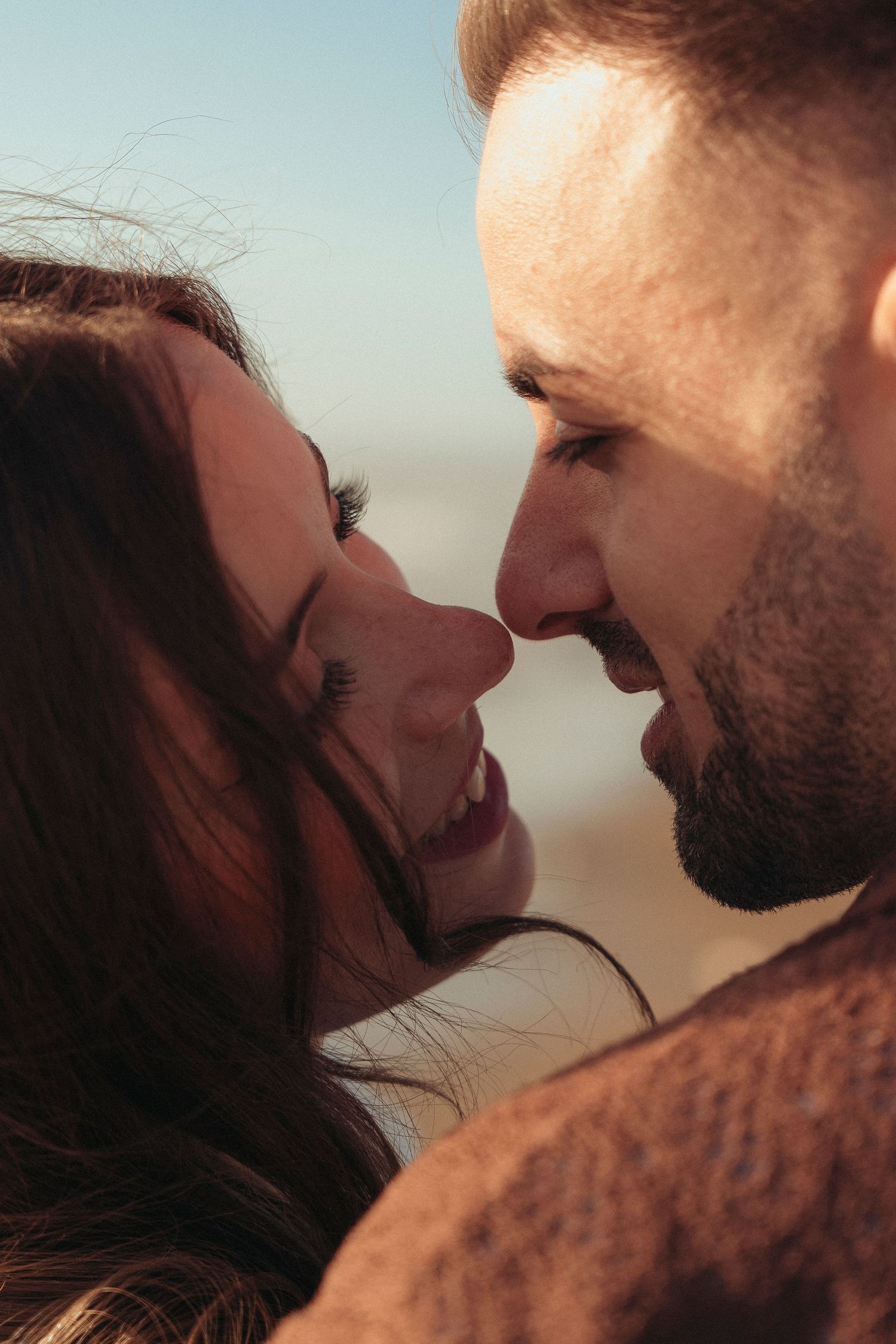 Intimate close-up portrait of a couple gazing at each other with love outdoors.