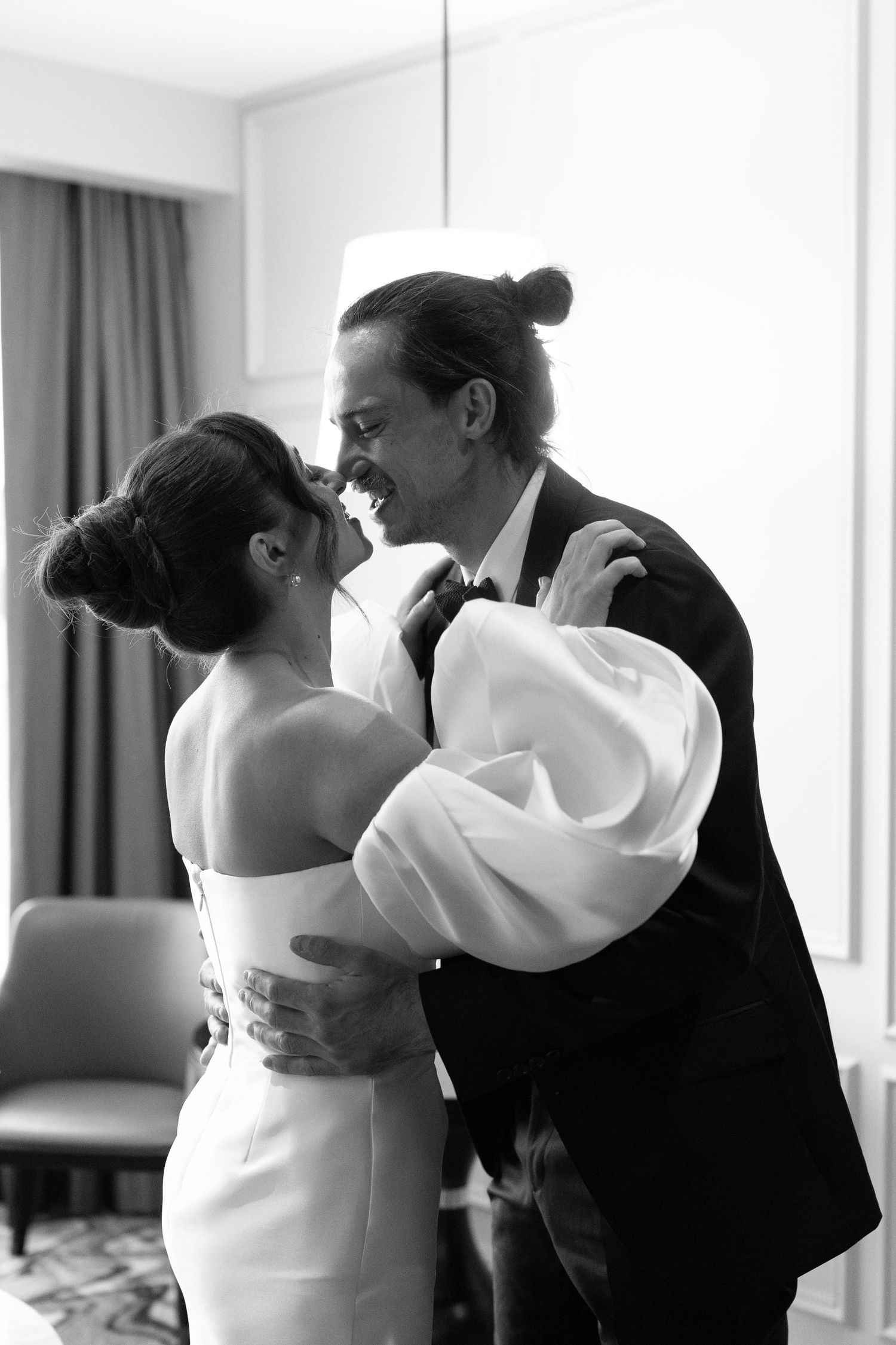 Black and white portrait of couple embracing in formal wedding attire.