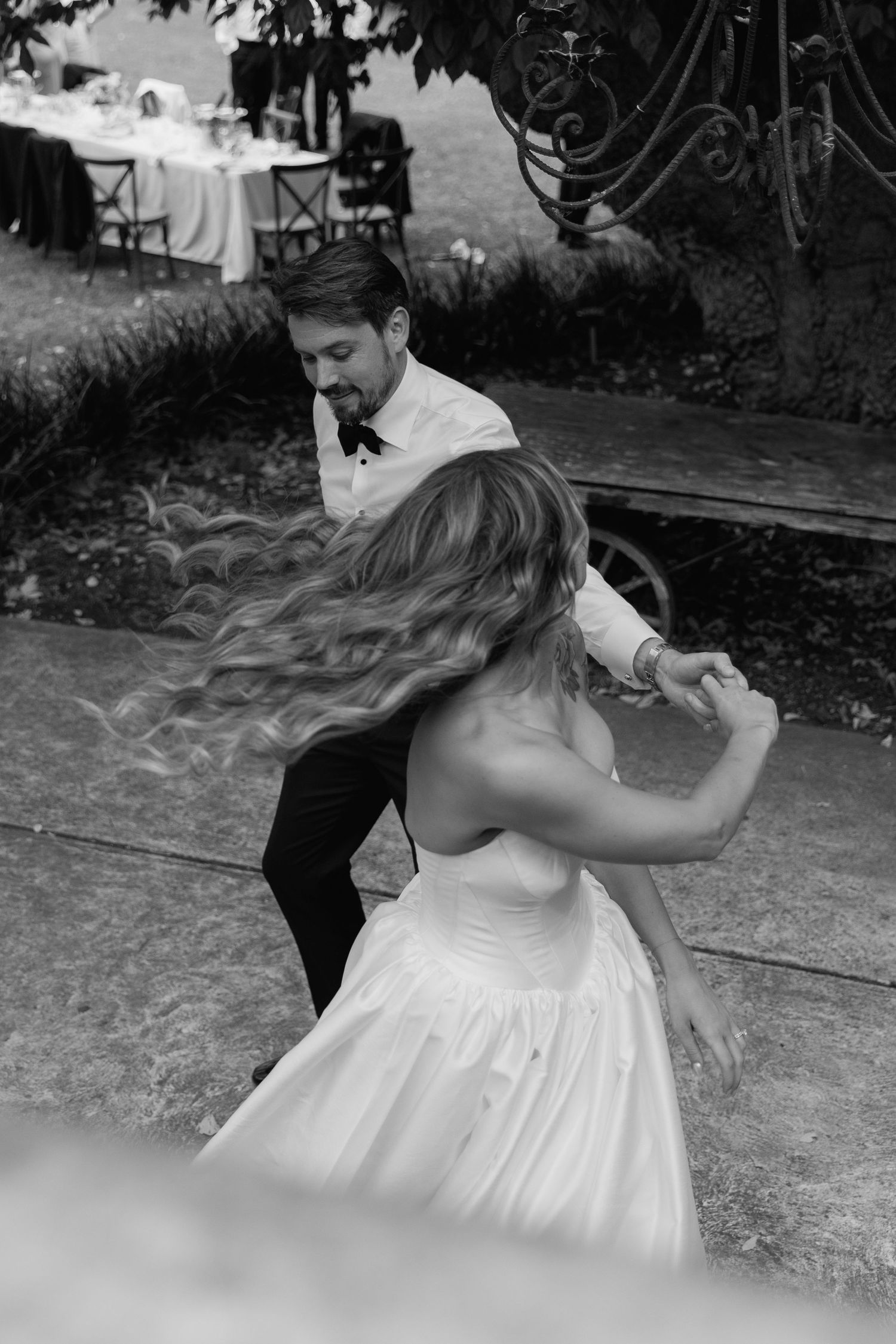 A black and white photo captures a dancing couple during their wedding reception.