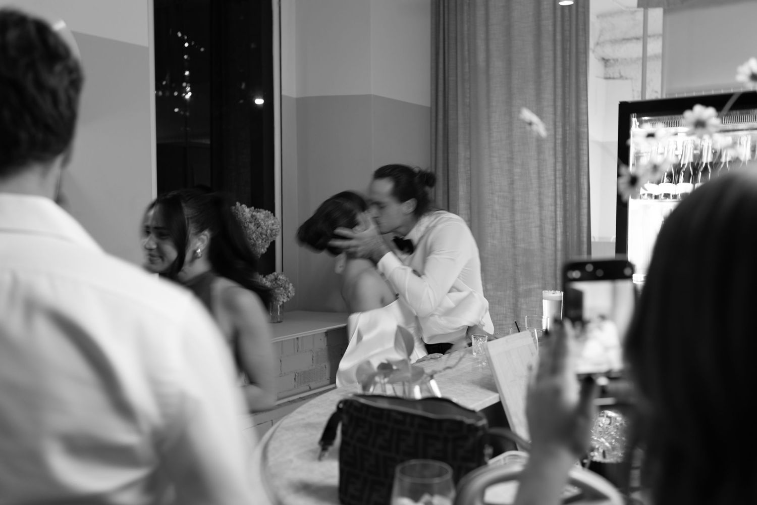 Black and white candid photo of celebration moment at party.
