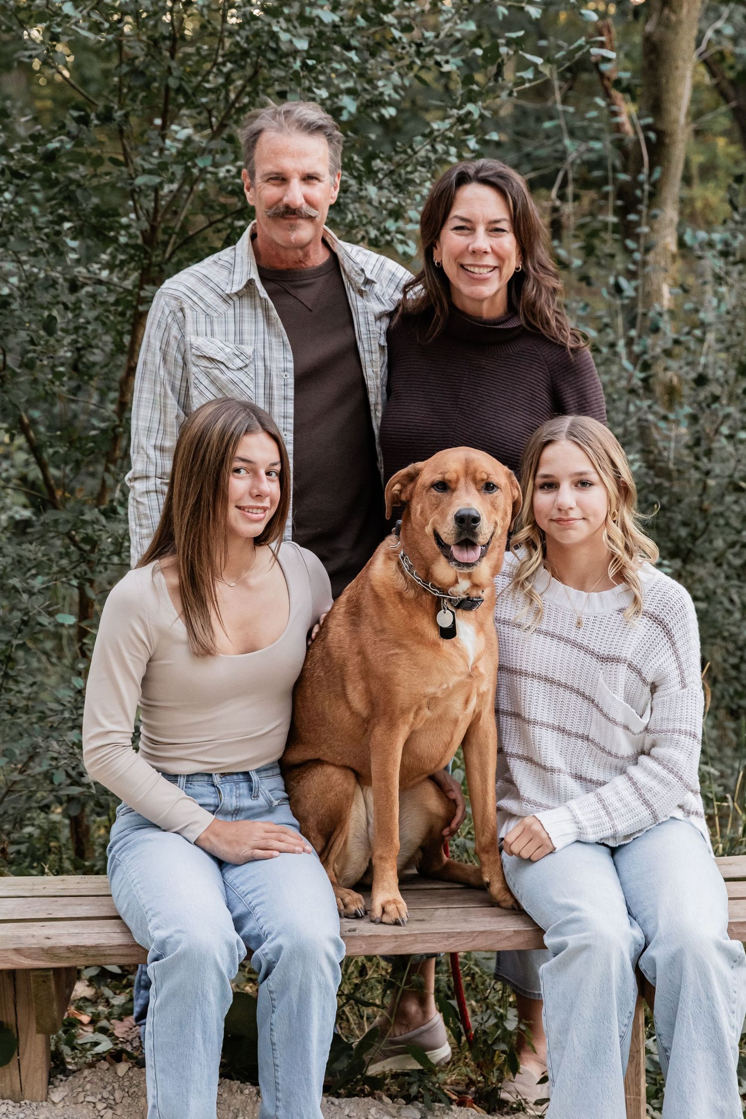 Family poses with their red lab
