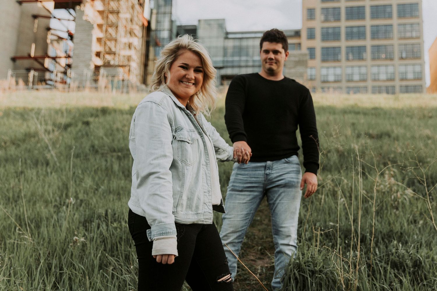 young woman pulls her fiance down a walking path