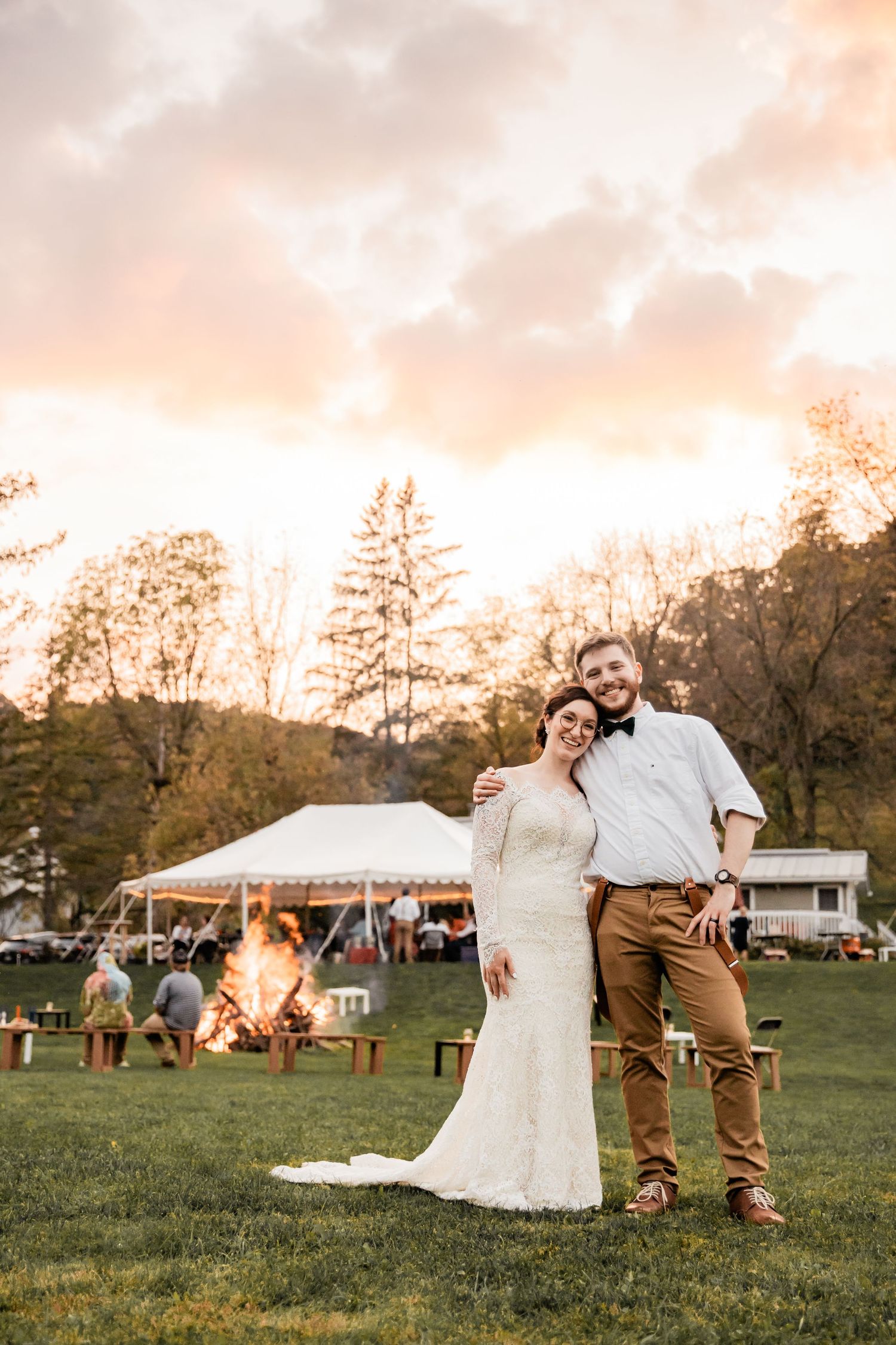 bride and groom posing in front of a huge bonfire during sunset at Briggs Outdoors