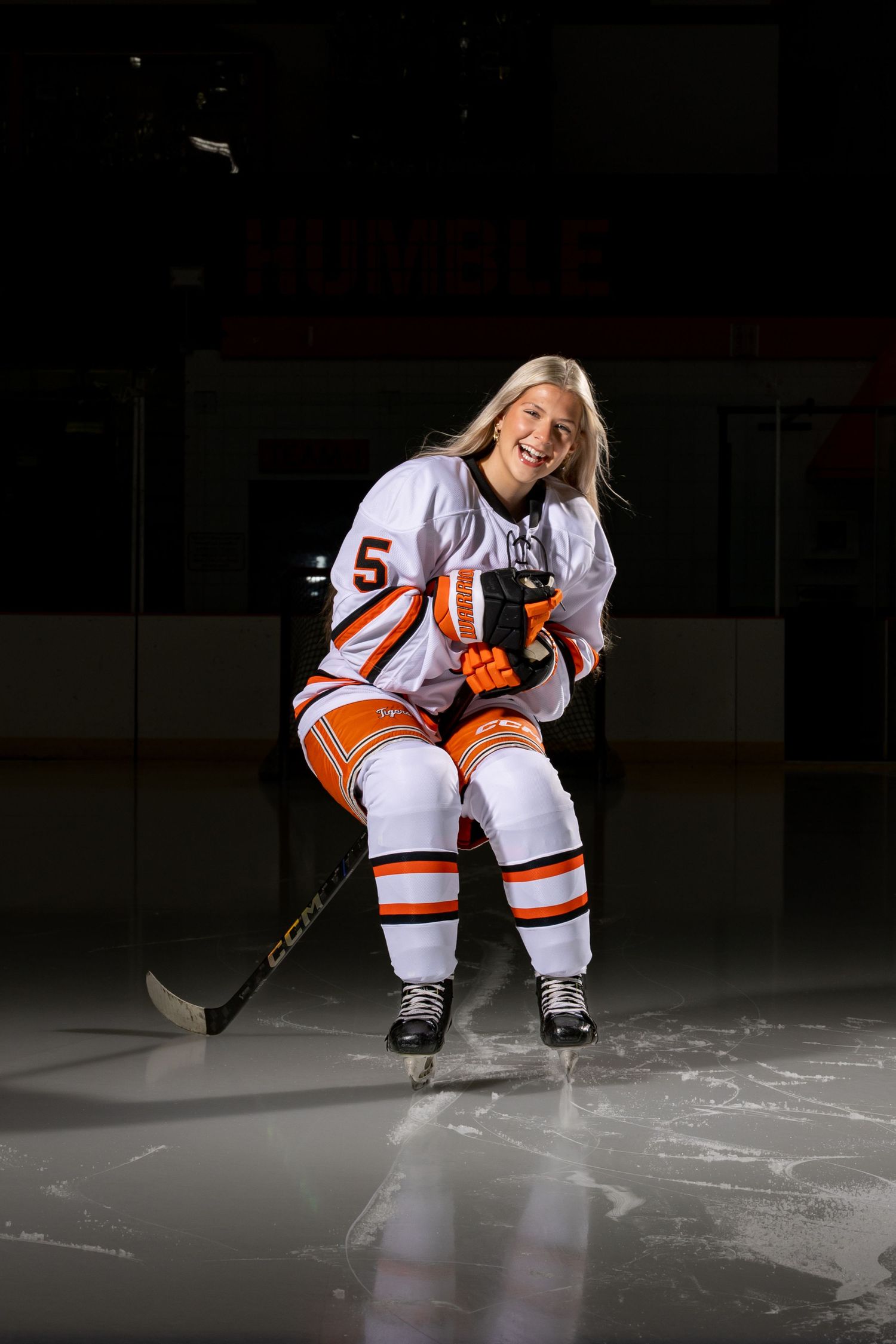 Farmington Tigers girls hockey player rides her stick like a broomstick for her media day pose