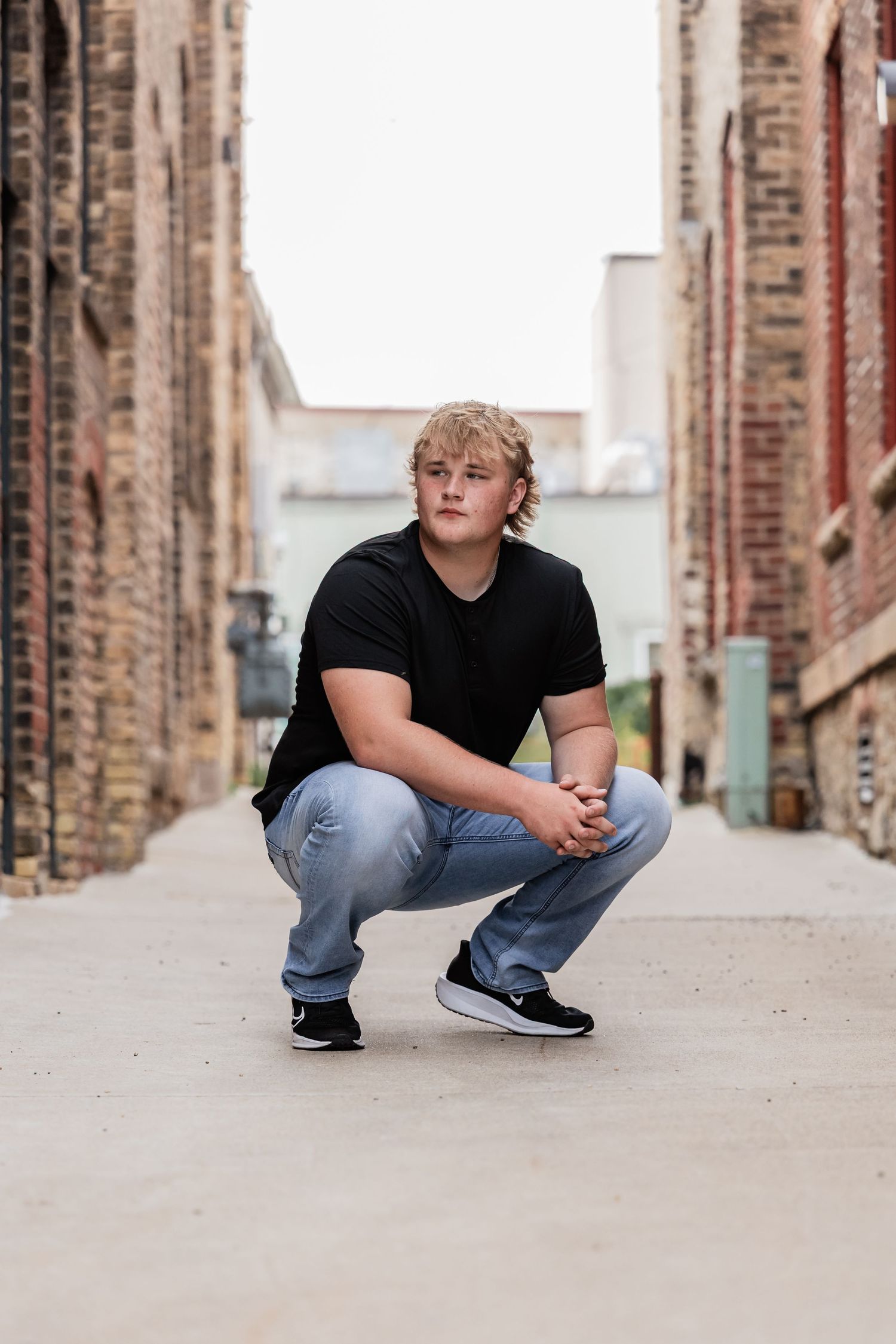 Isaac crouches in an urban alleyway in downtown Northfield