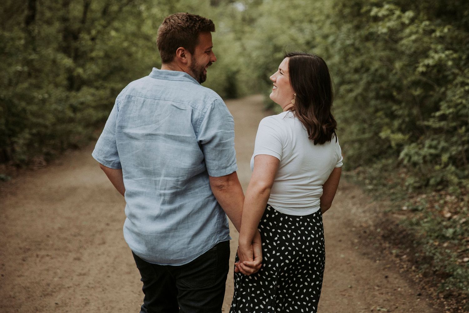 young couple walks down dirt road
