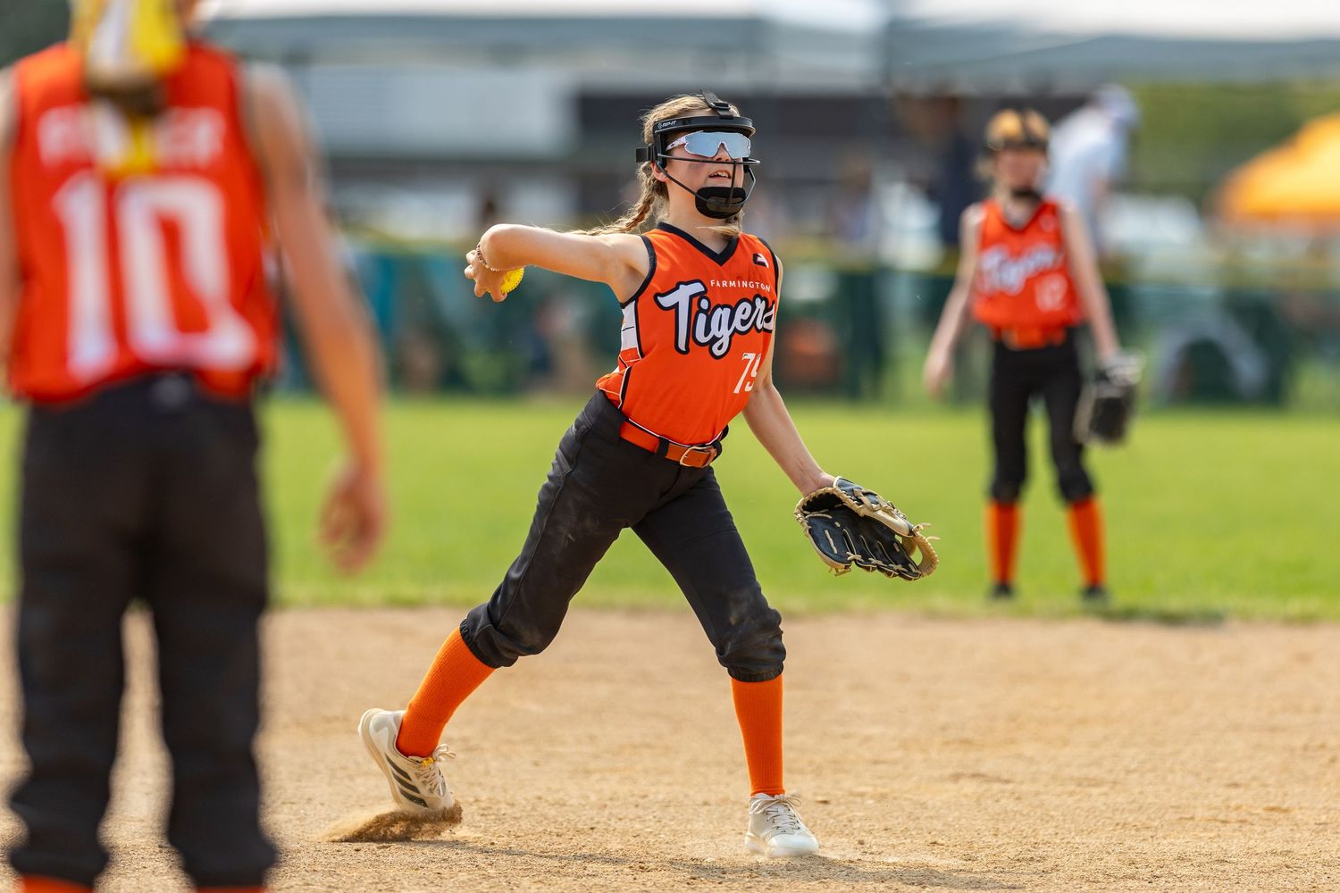 Youth softball player goes to make the throw to first base