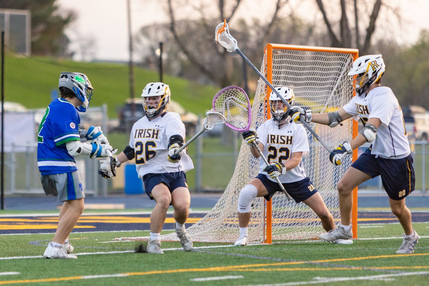 Rosemount Irish lacrosse players block an attacker from taking a shot on goal