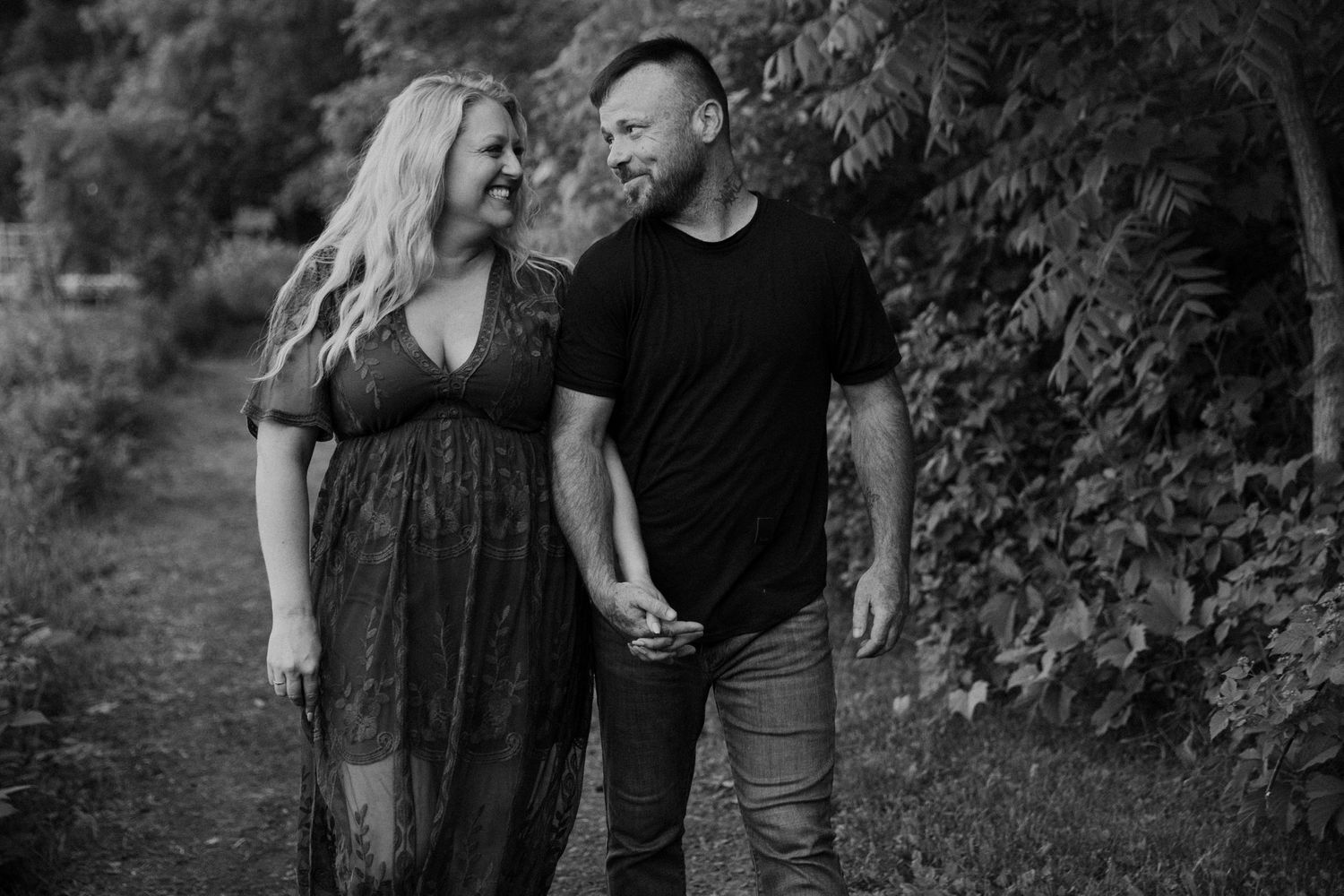 Smiling couple walks hand in hand as they stare into each other's eyes