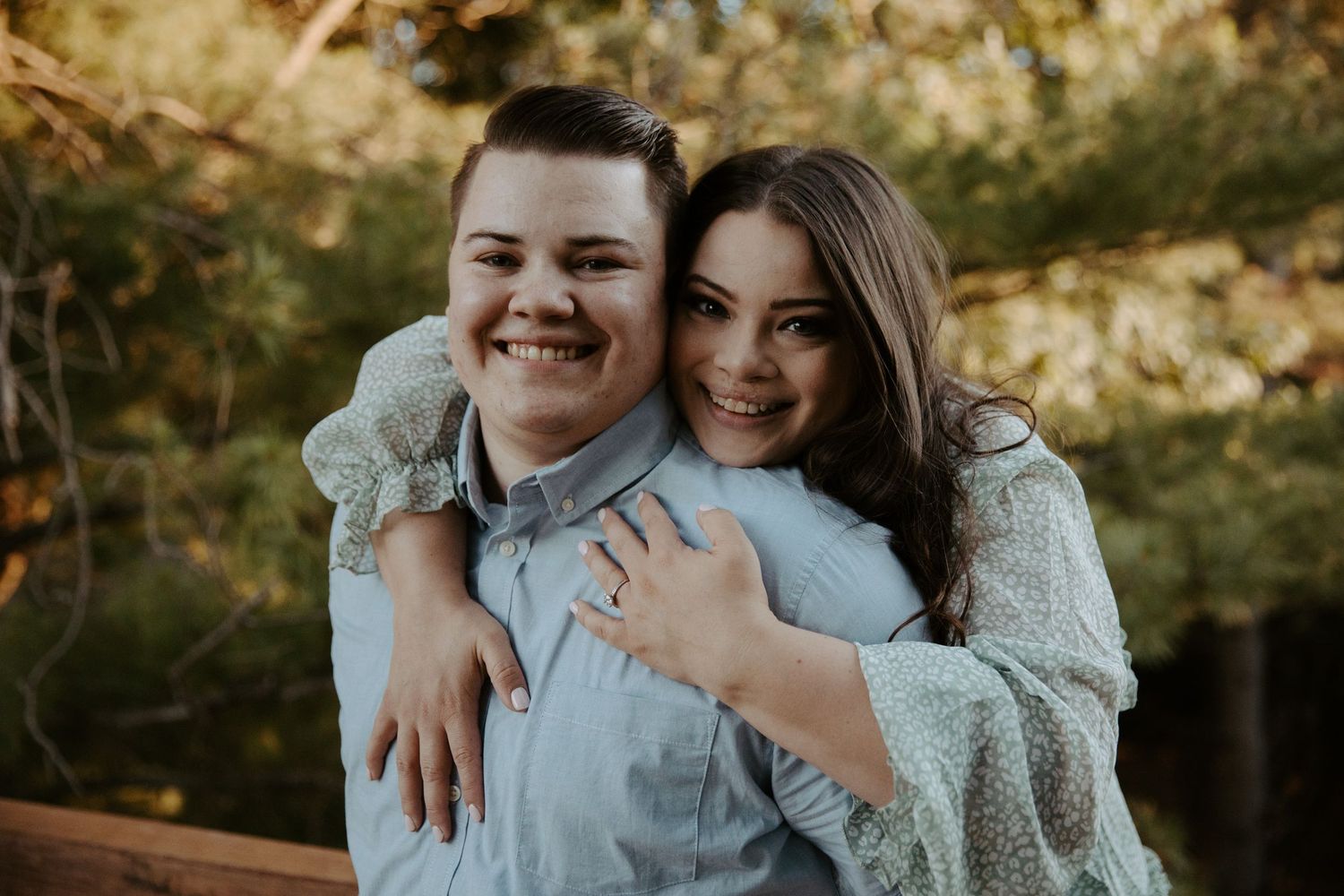 high school sweethearts in loving embrace on a suspension bridge in a nature park