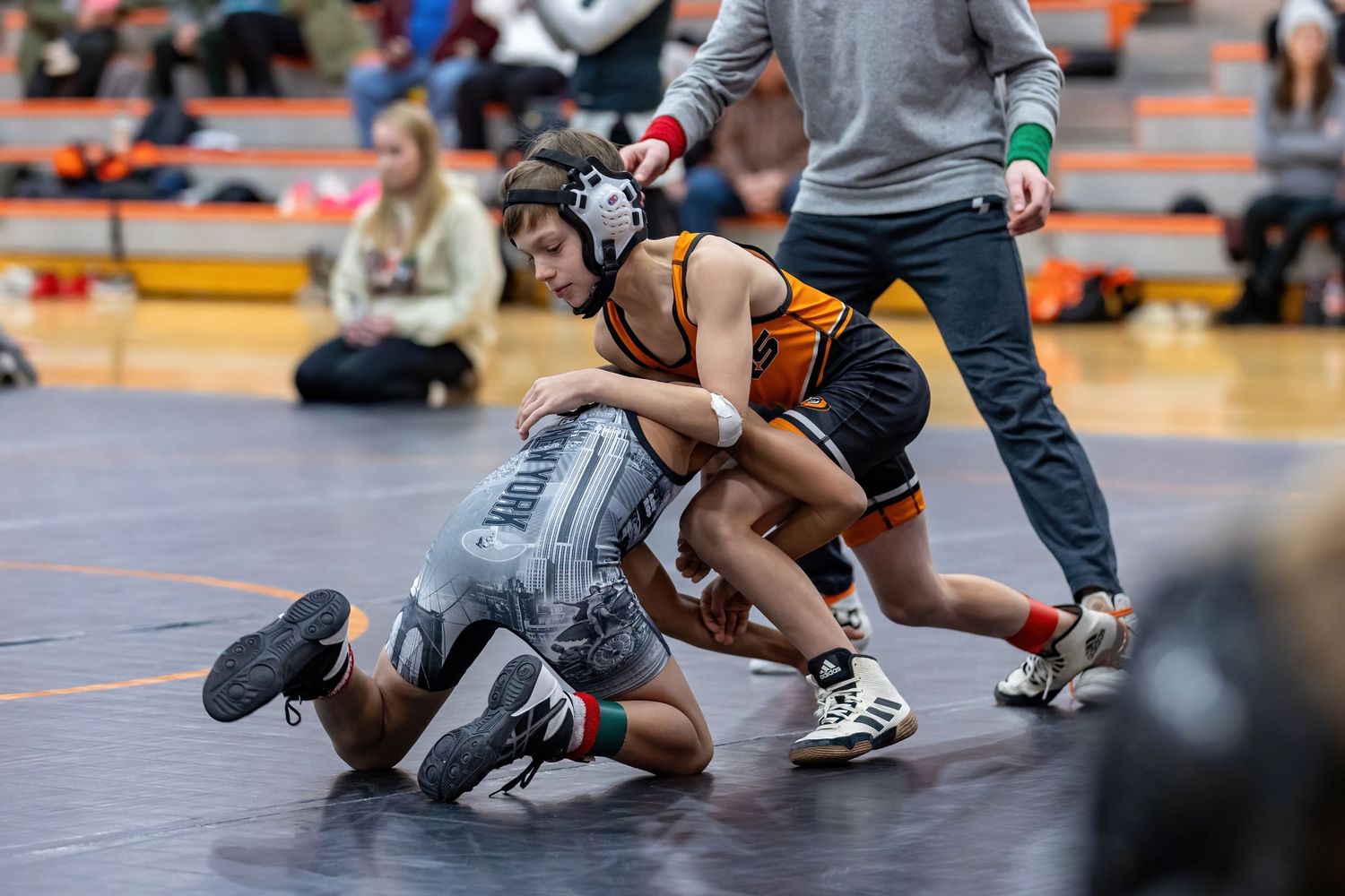 Youth wrestler attempts to grapple his opponent tot he floor