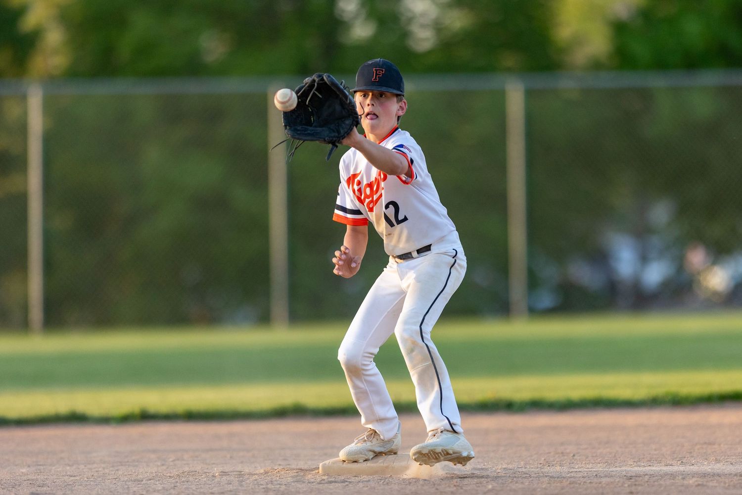 Farmington Tigers youth baseball player reaches out to make the catch for an out