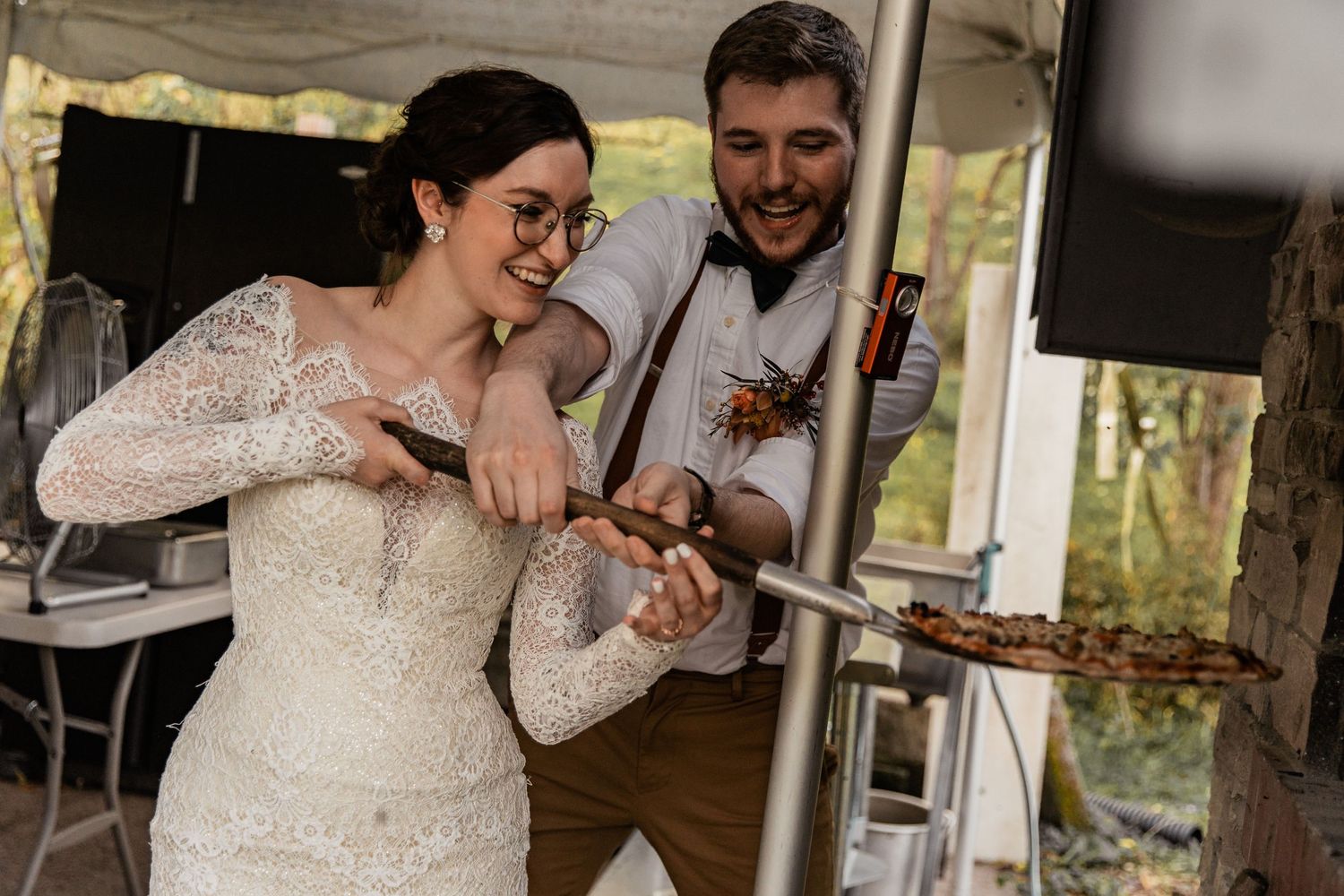bride and groom make their own brick oven pizza