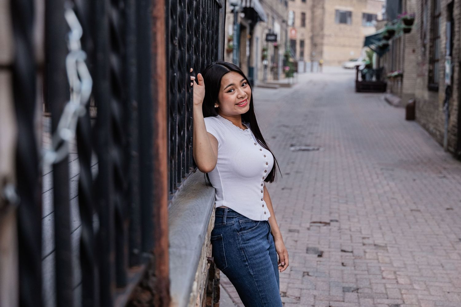 Nina Galindez lightly grabs on to the iron railing of a patio above her