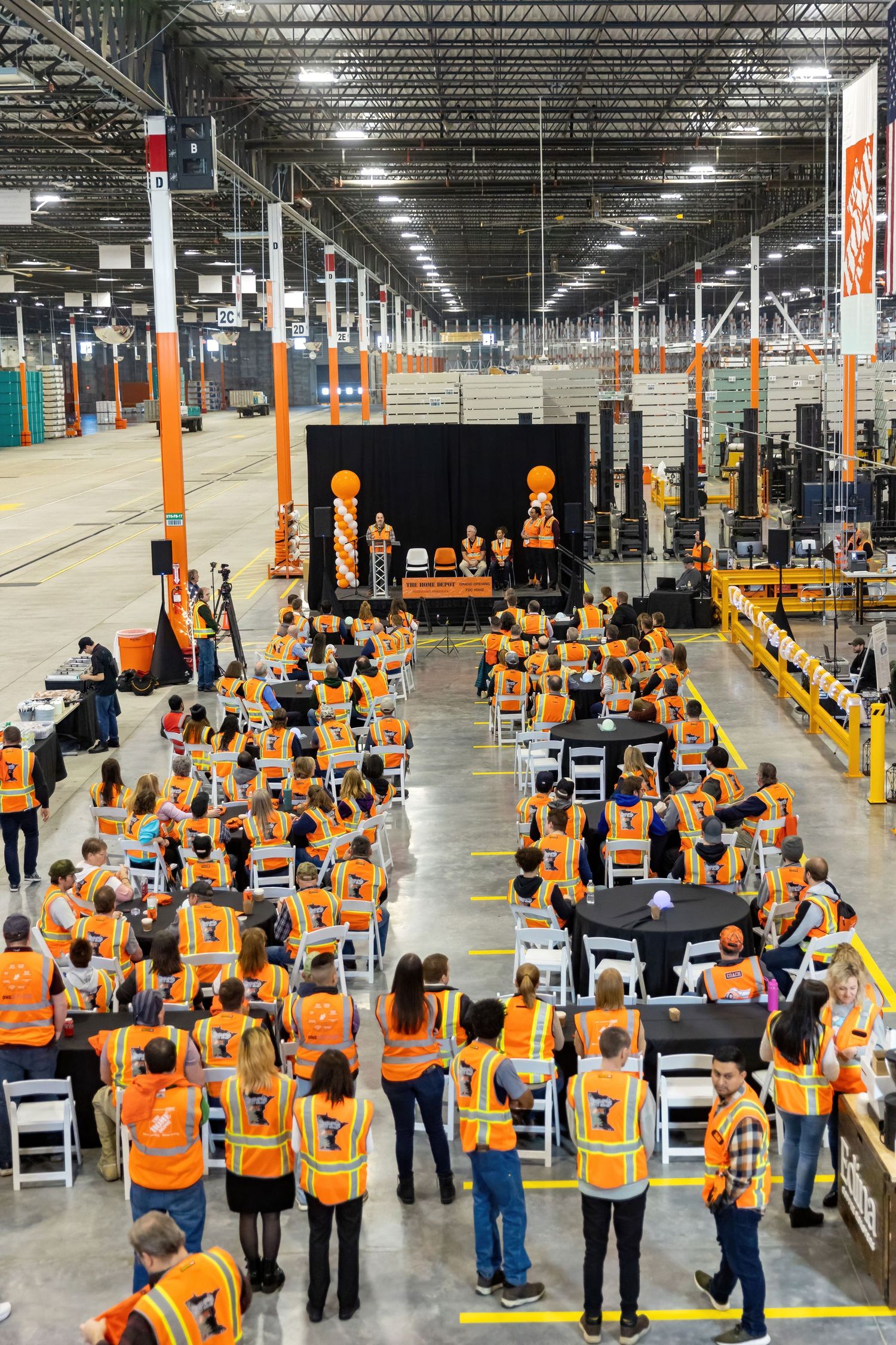 Employees listen to speeches from management and the mayor of Rosemount as they open the new warehouse