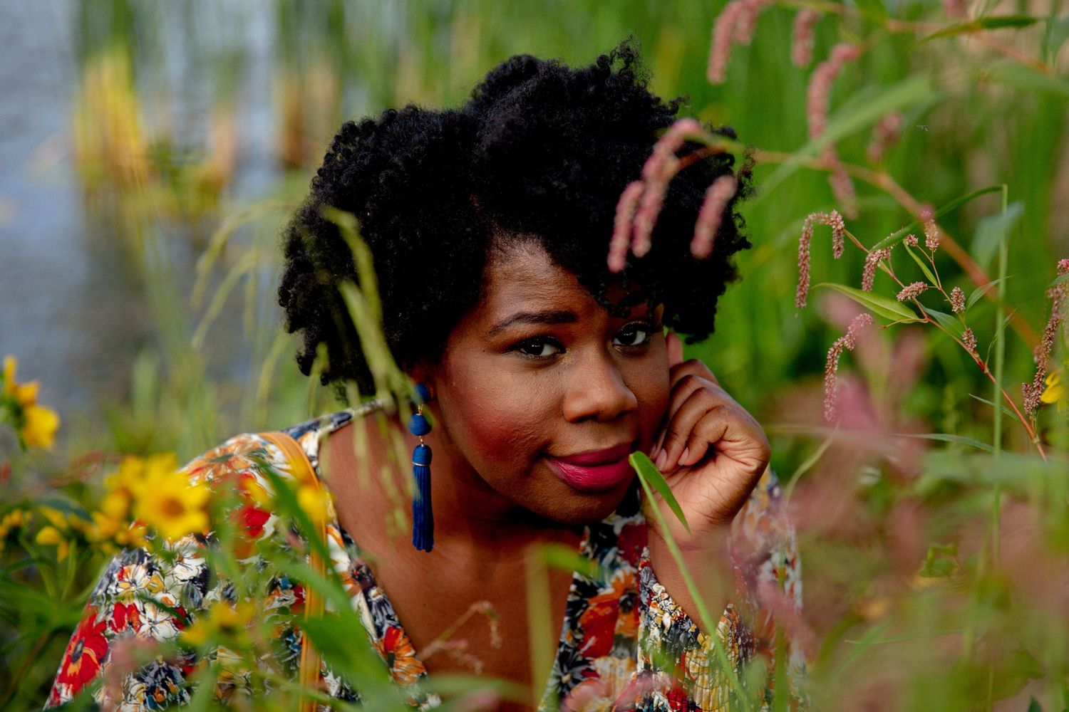 Beautiful woman of color surrounded by summer foliage