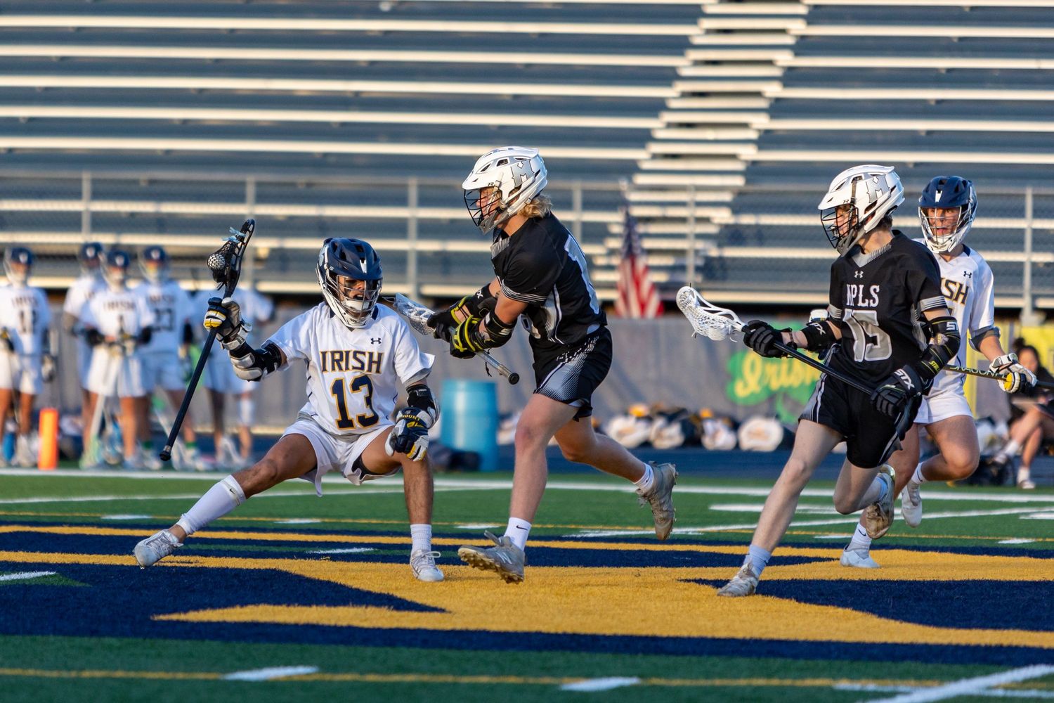 Rosemount Irish lacrosse player crouches to dodge a defender