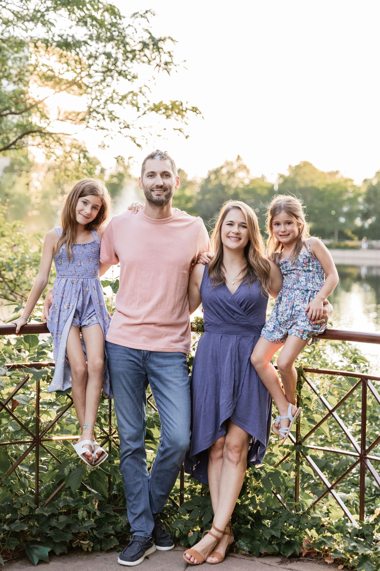 Iliev family sits on on a railing with a golden sunset over the lake behind them