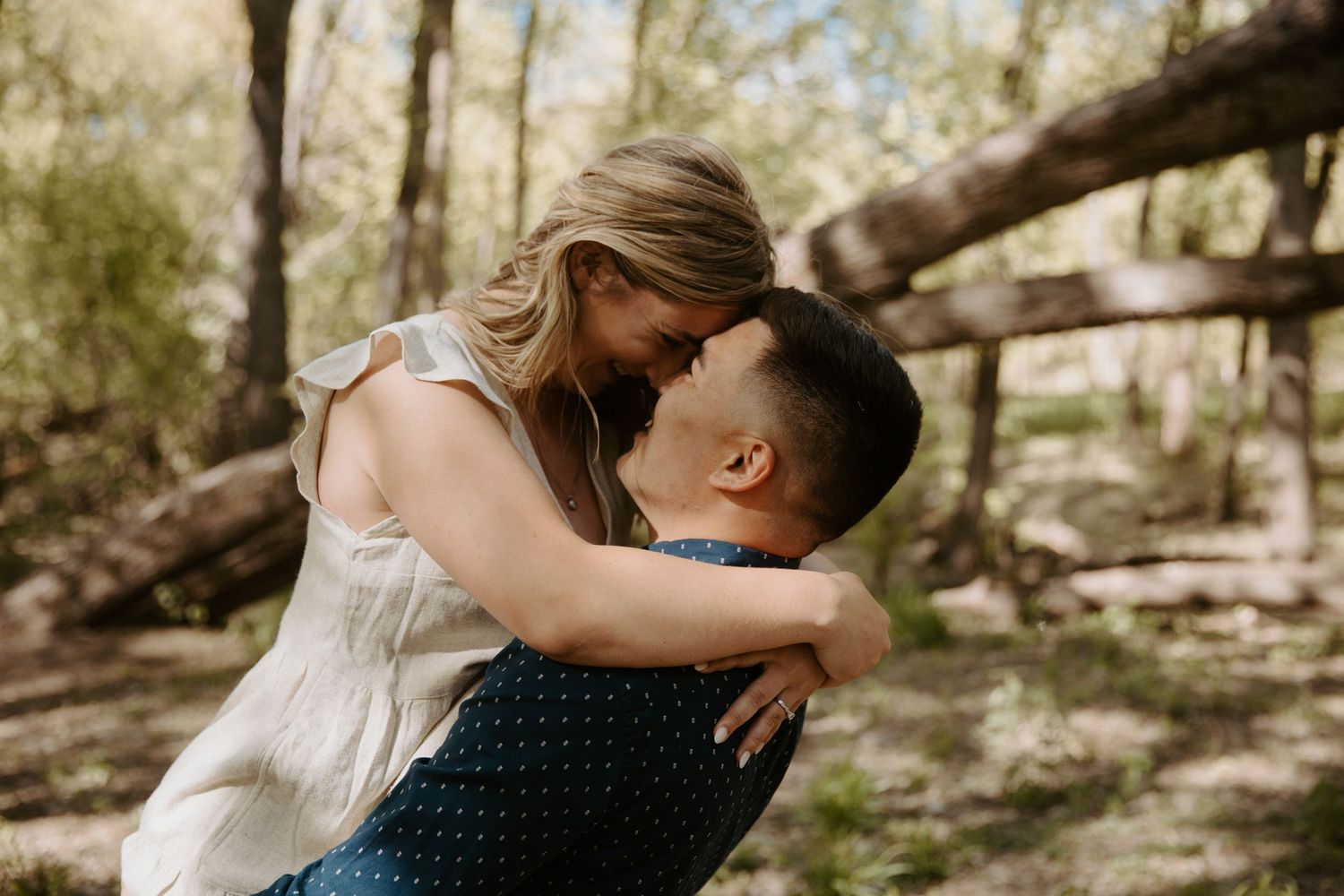 Young man picks up his fiance and pulls her in for a kiss