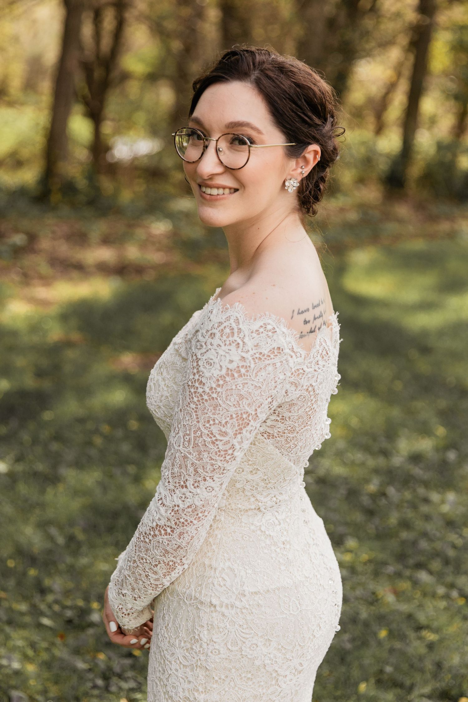 bride poses from the side to show off her dress on her wedding day