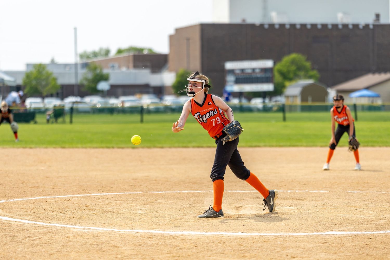 Youth softball player throw a strike over the plate