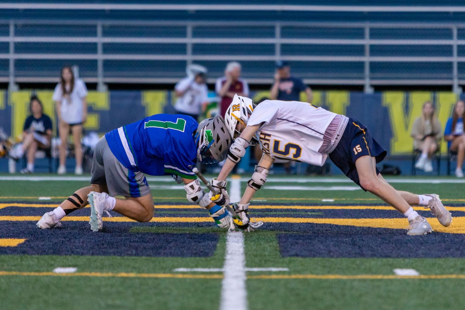 Rosemount Irish lacrosse player attempts to win a faceoff