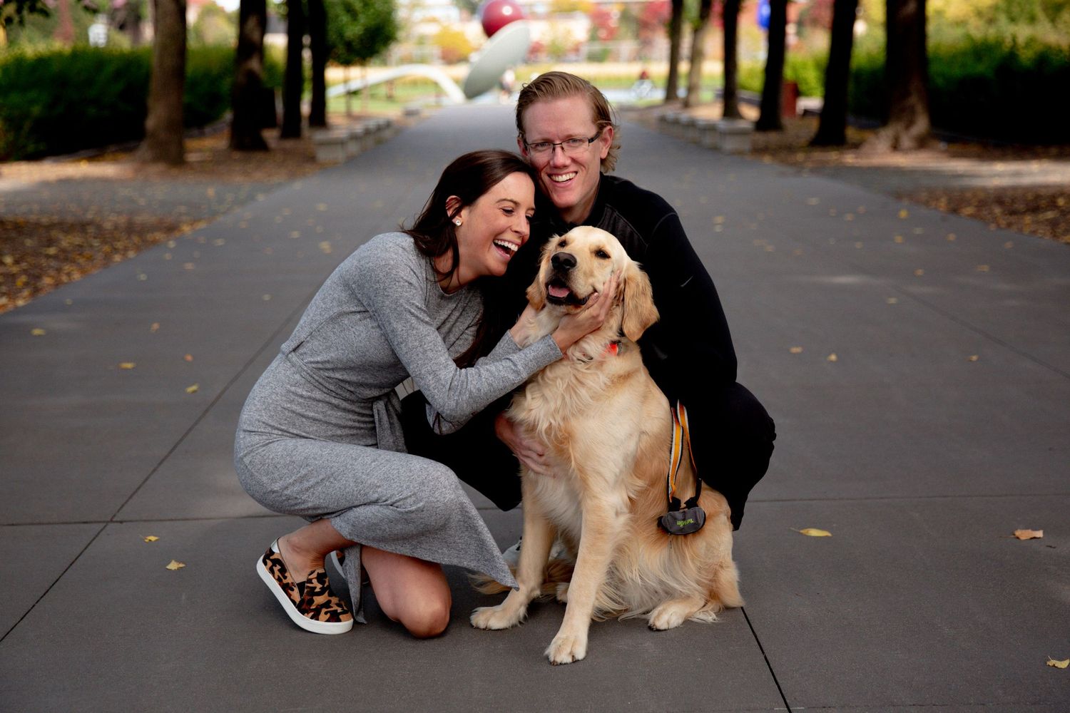 young woman cuddles with her dog and boyfriend at minneapolis sculpture garden