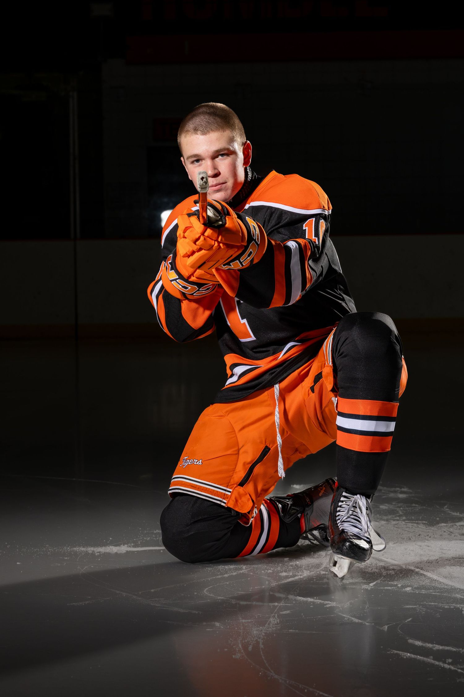Farmington Tigers boys hockey player takes aim at the camera for his media day pose