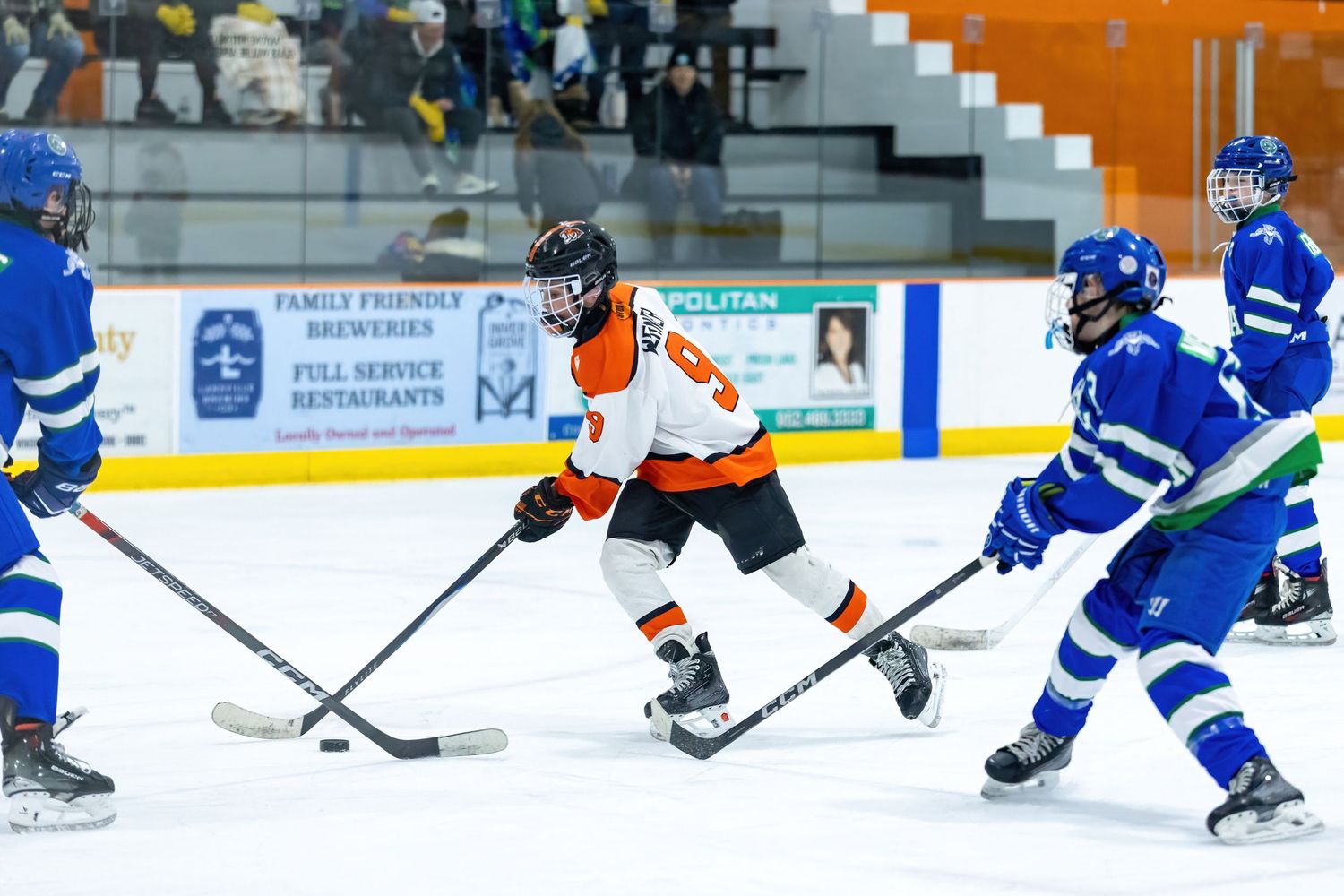 Youth hockey player dekes past his defender as he shoots on the goal