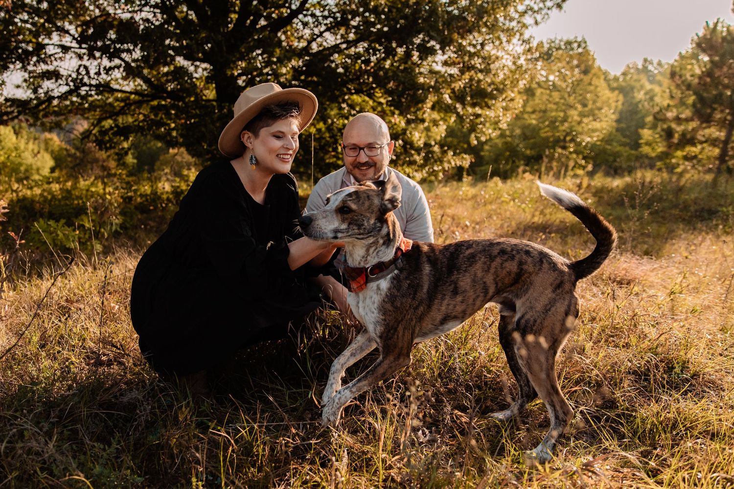 husband and wife look lovingly at their puppy