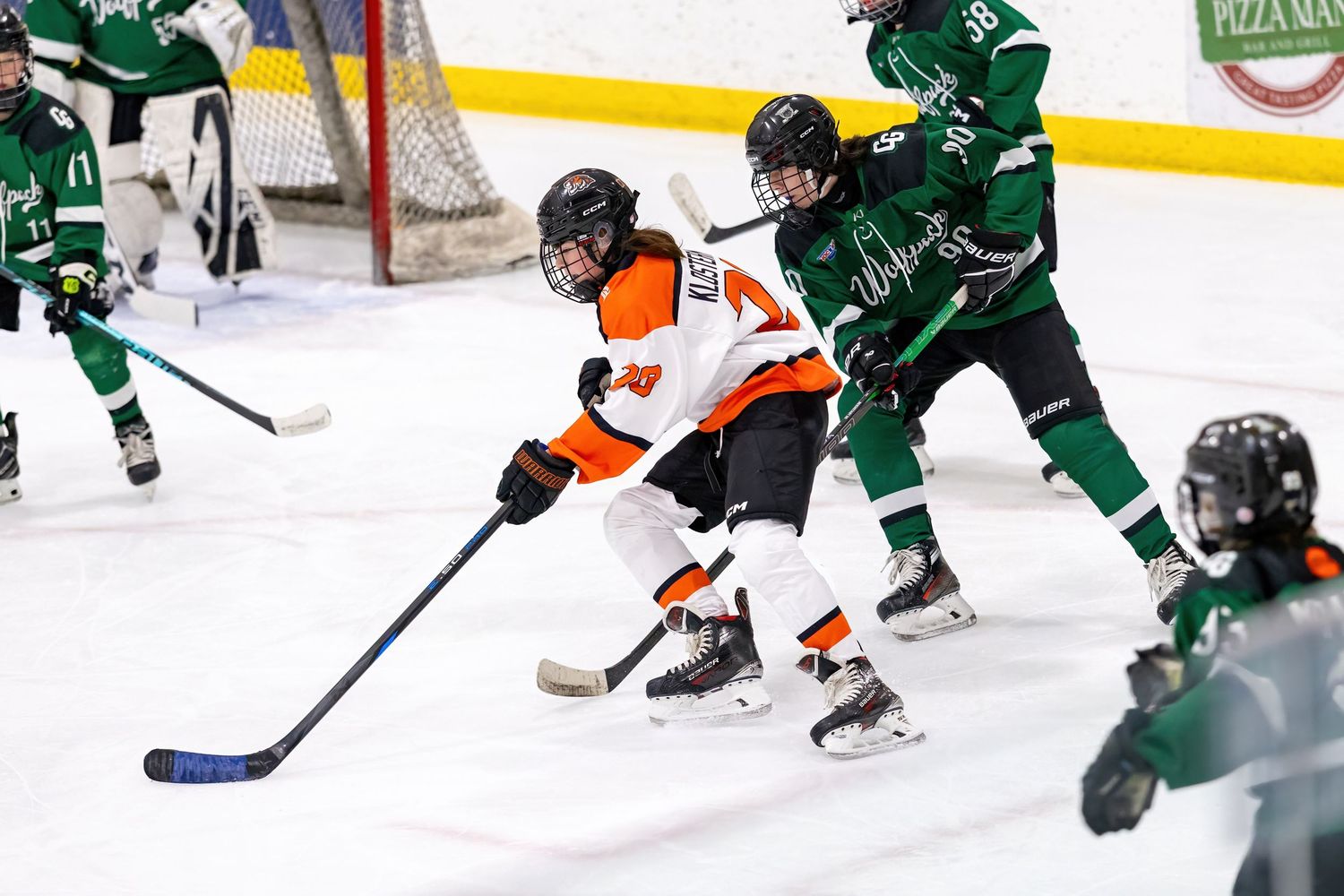 Youth hockey player skates around a defender to have a chance to score