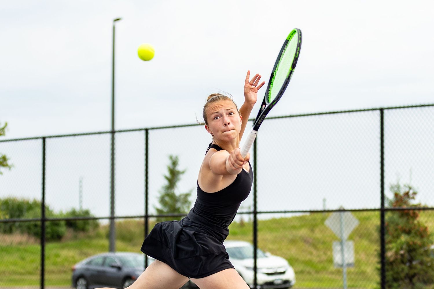Farmington Tigers tennis player extends to hit her backhand return