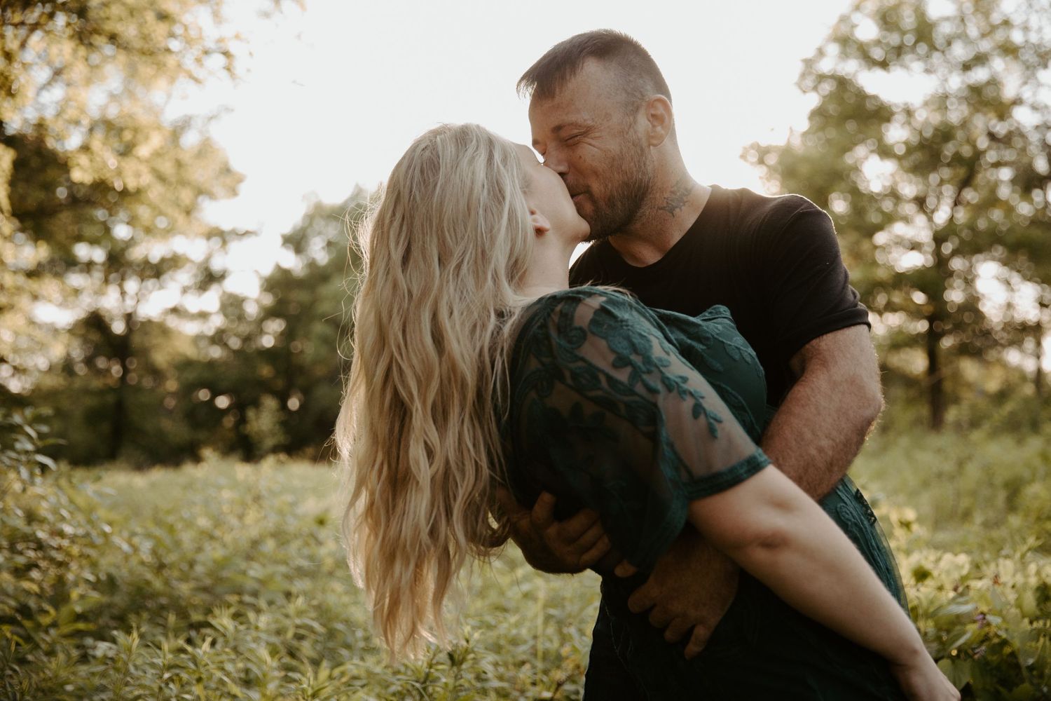 Man dips his fiance as he leans in for a kiss