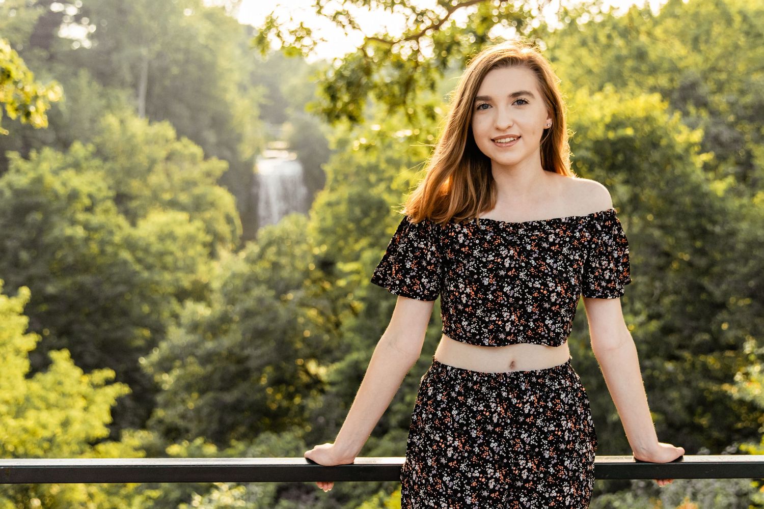 Sydney leans against a metal railing as Minnehaha Falls rages behind her