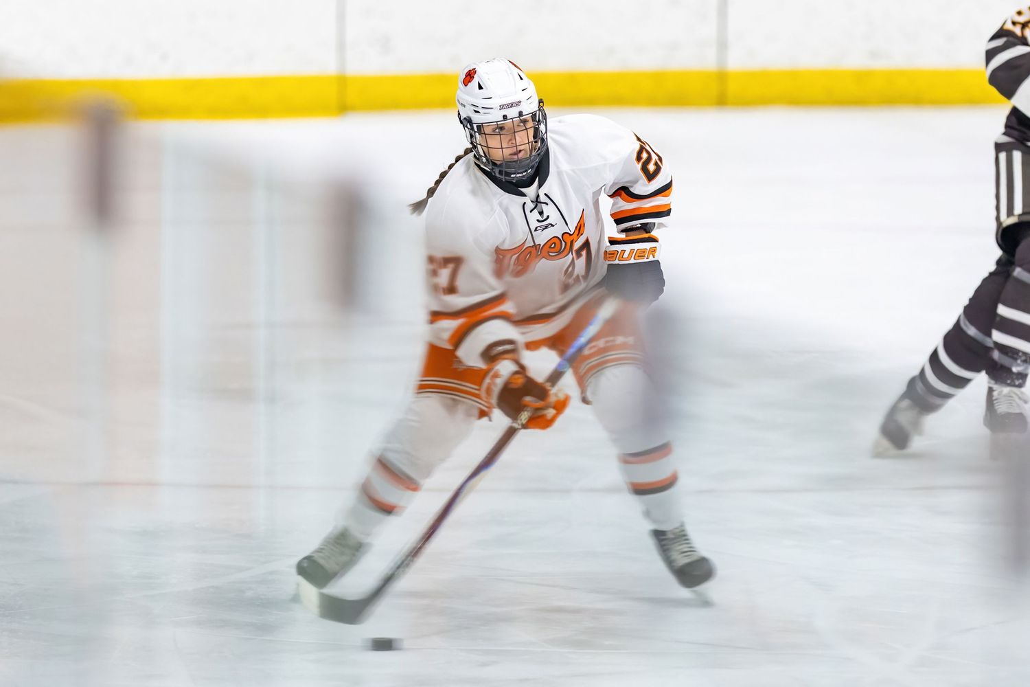 Farmington Tigers girls hockey player brings the puck up the ice