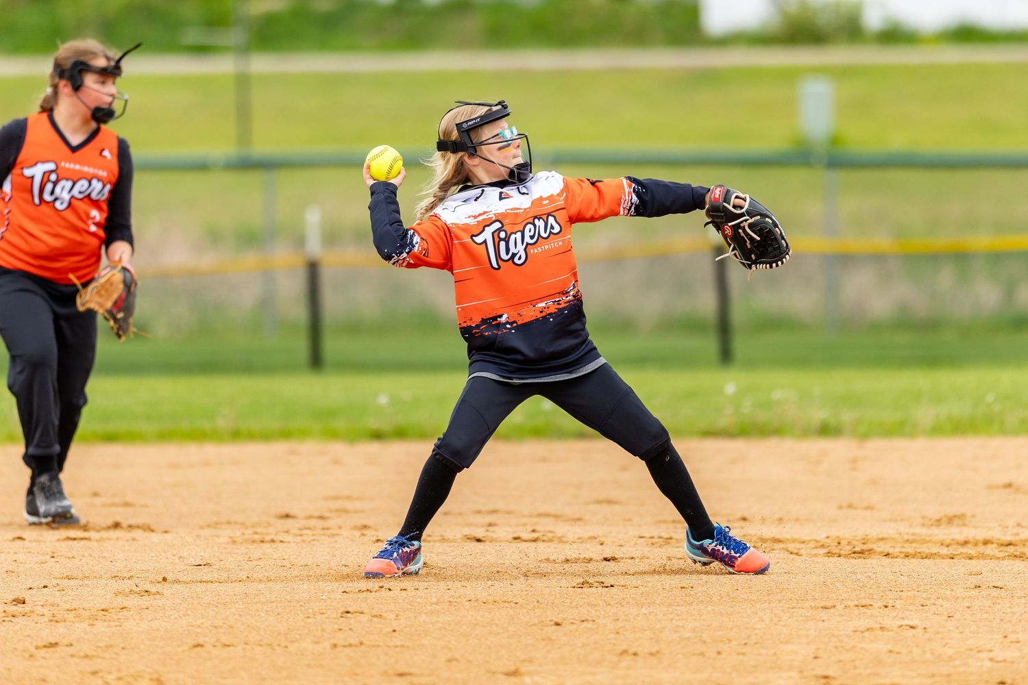 Youth softball player aims to throw the ball to first for the force out