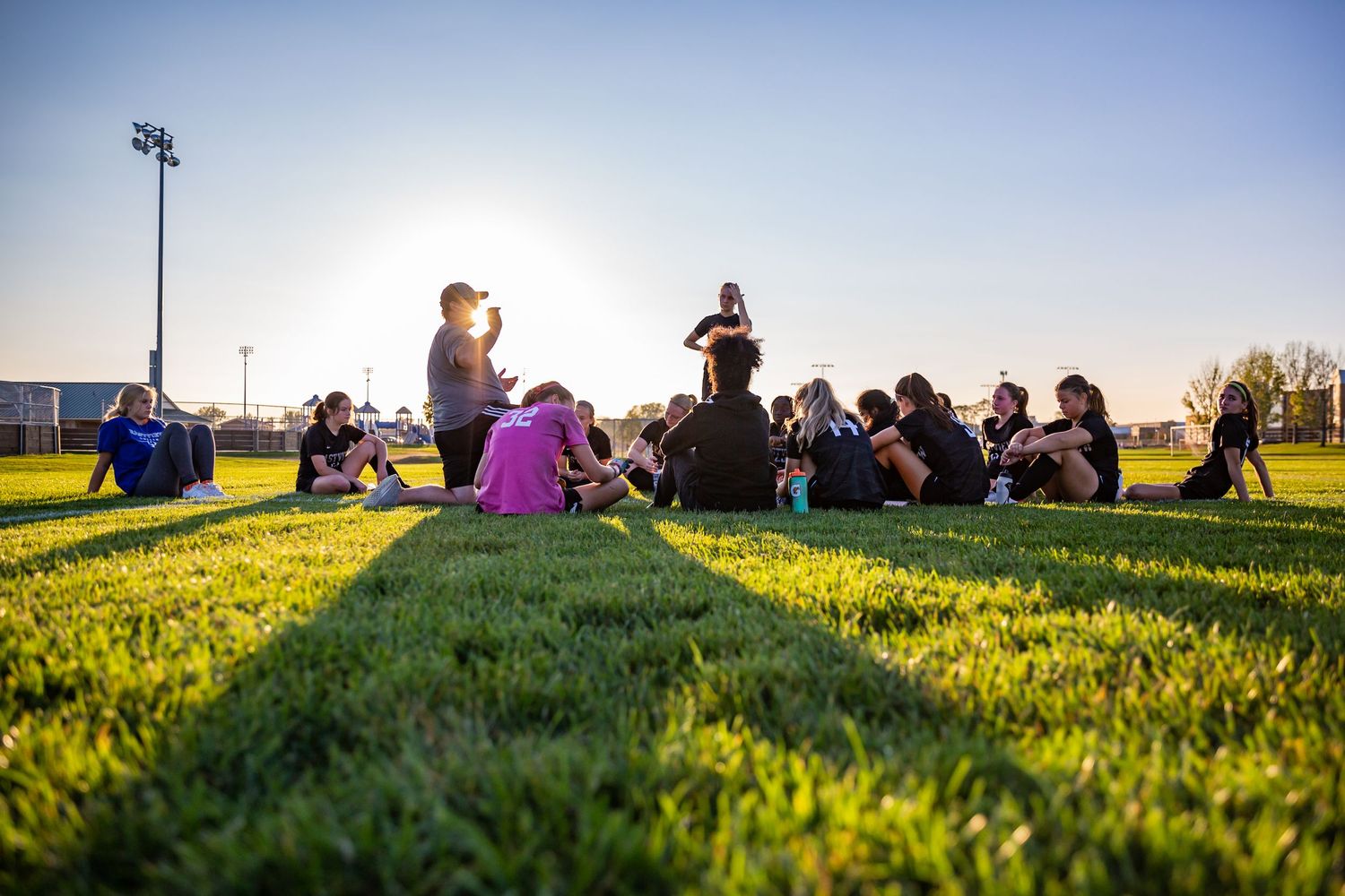 eastview high school girls soccer team huddle at sunset