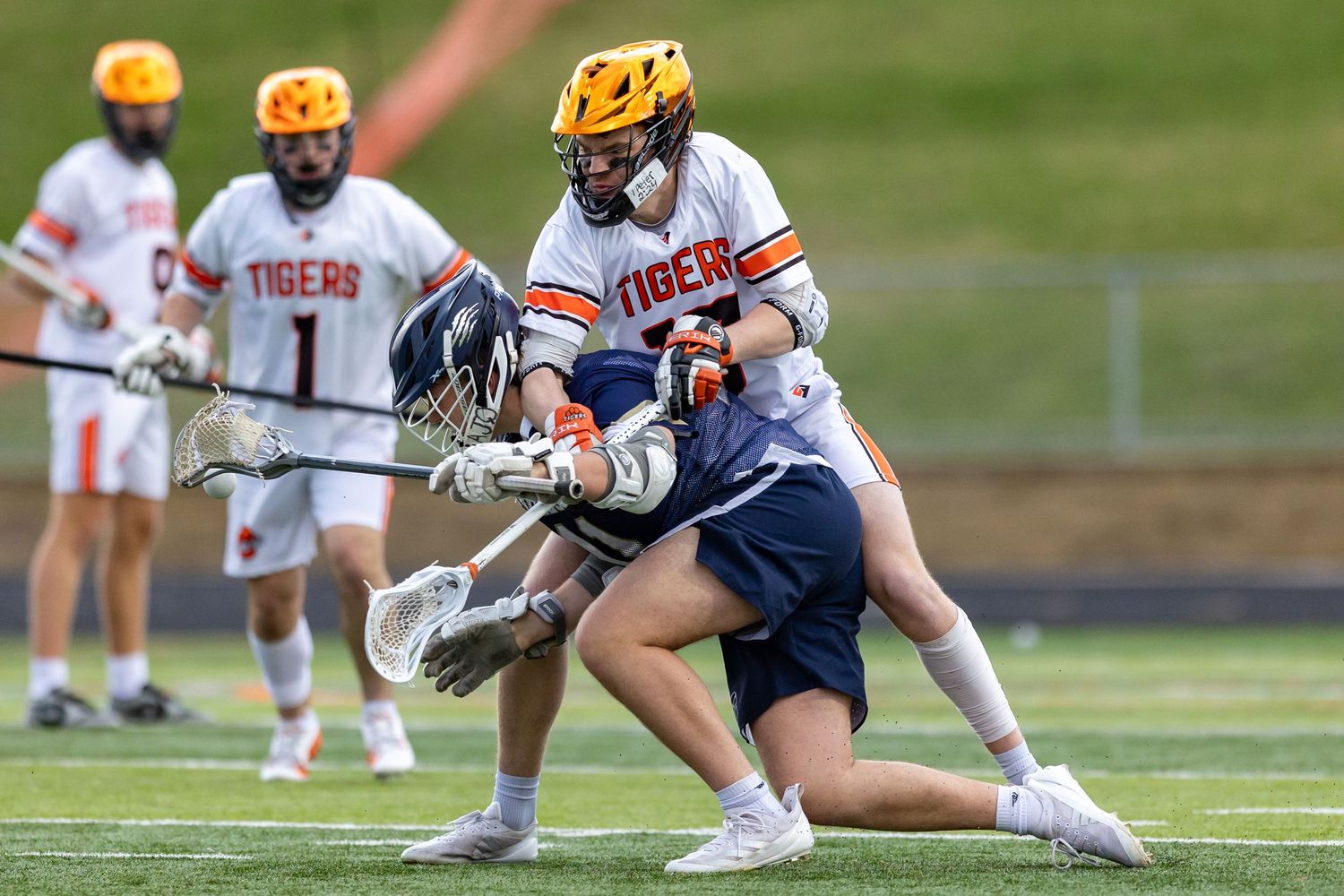 Farmington Tigers boys lacrosse defender stops his attacking opponent