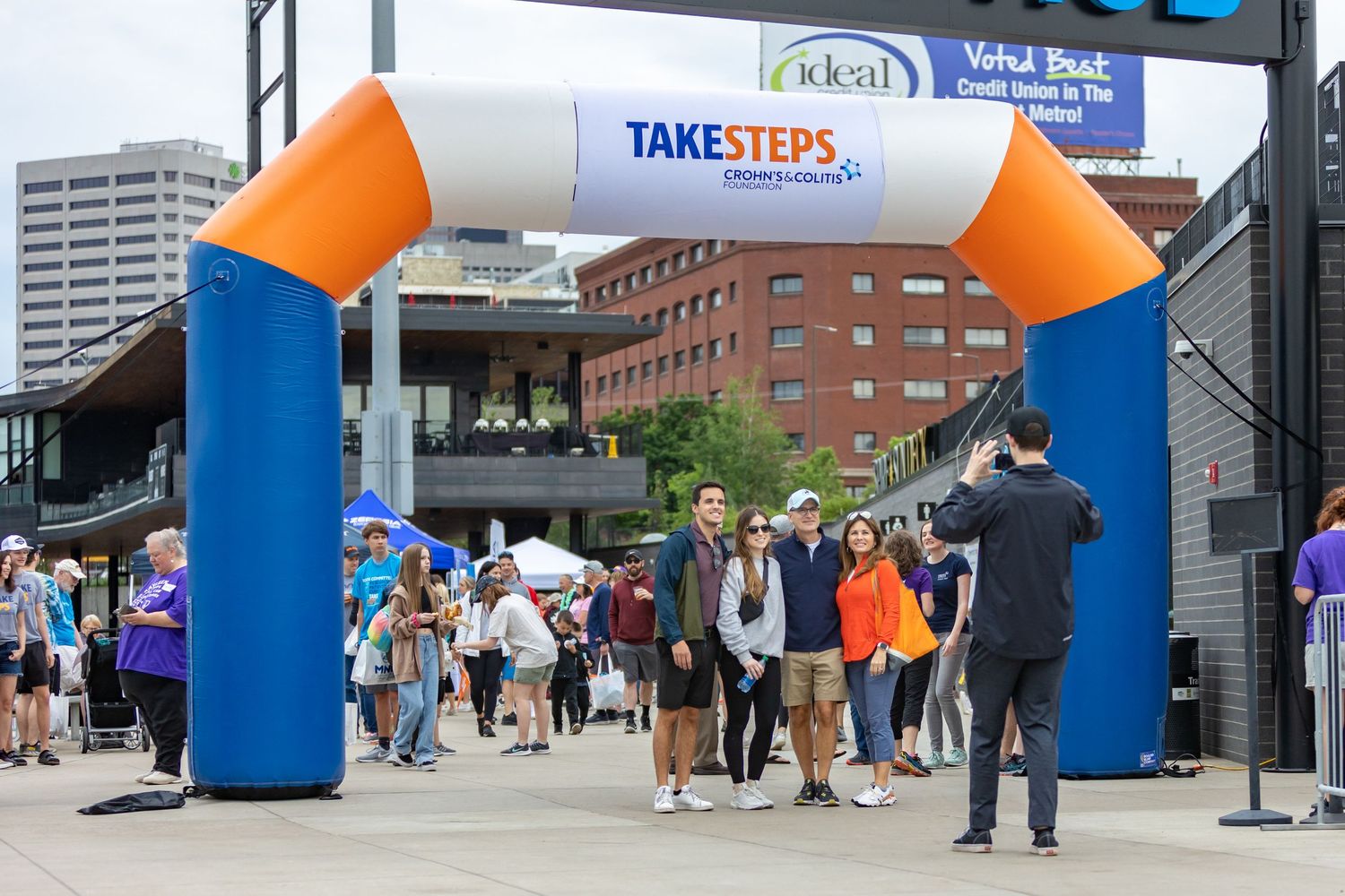 Attendees walk under the Crohn's and Colitis fun run inflatable arch