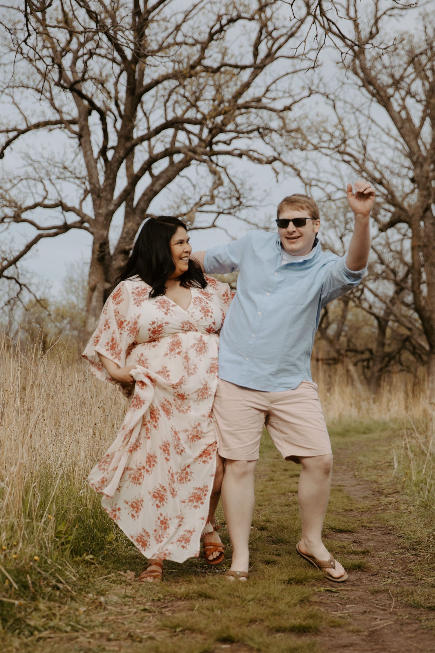 Engaged couple bumps hips as they laugh with each other