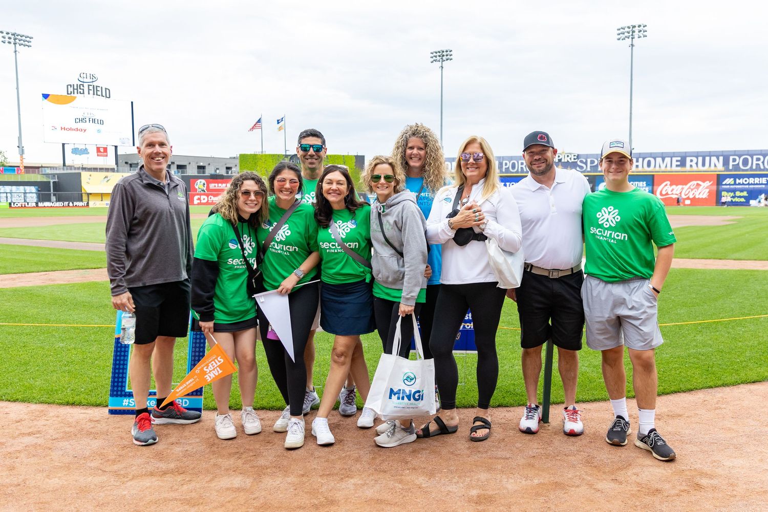 Attendees and organizers pose for a photo on the warning track of CHS Field for the Crohn's and Colitis fun run