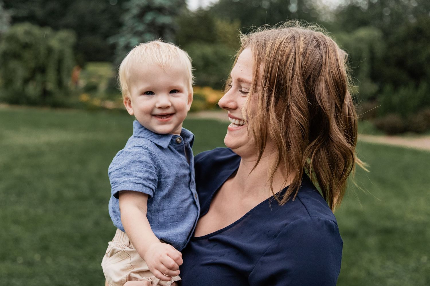 Mom holds her baby boy as they both smile at each other